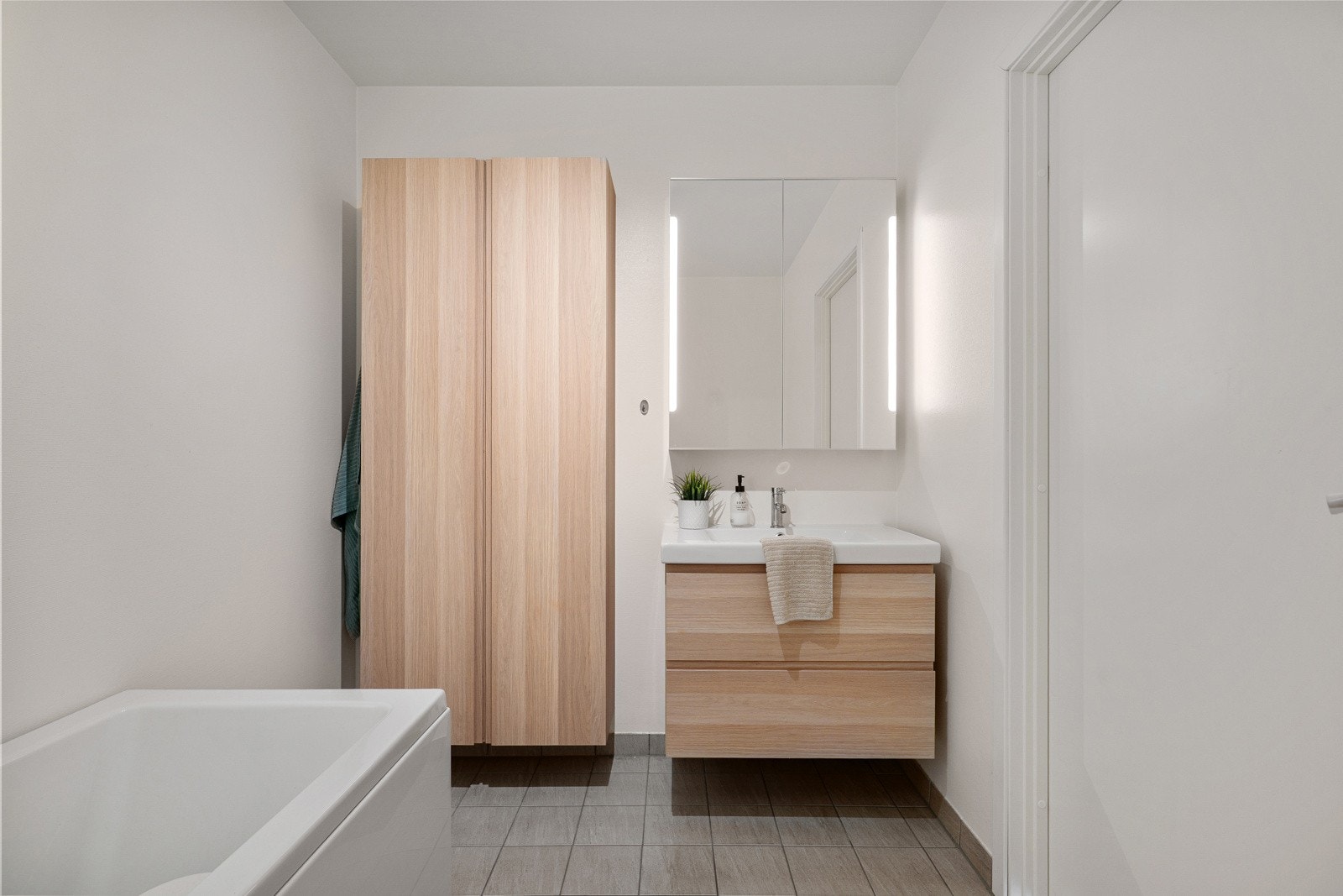 Baderomsinnredningen består av seksjon med servant, 2 stk høyskap, speilskap med belysning, badekar med dusjvegg og toalett. Galleribilde