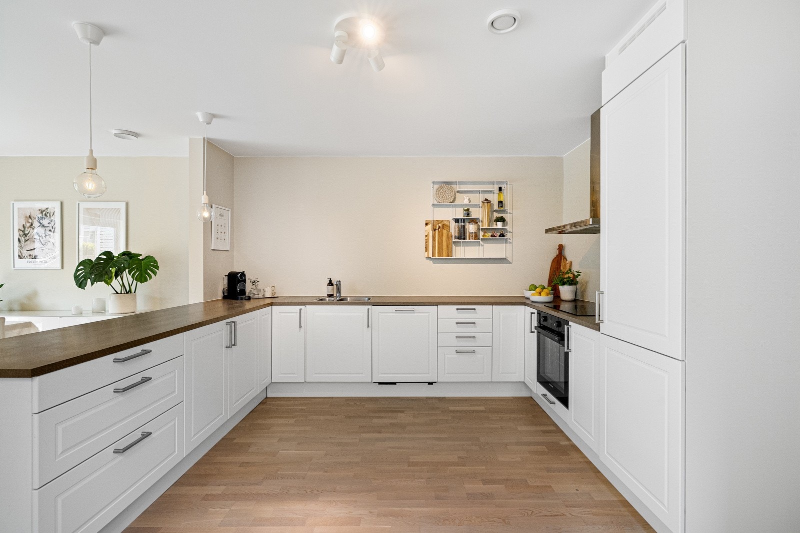 Kjøkkeninnredningen består av hvite fronter med en benkeplate i tre. Galleribilde