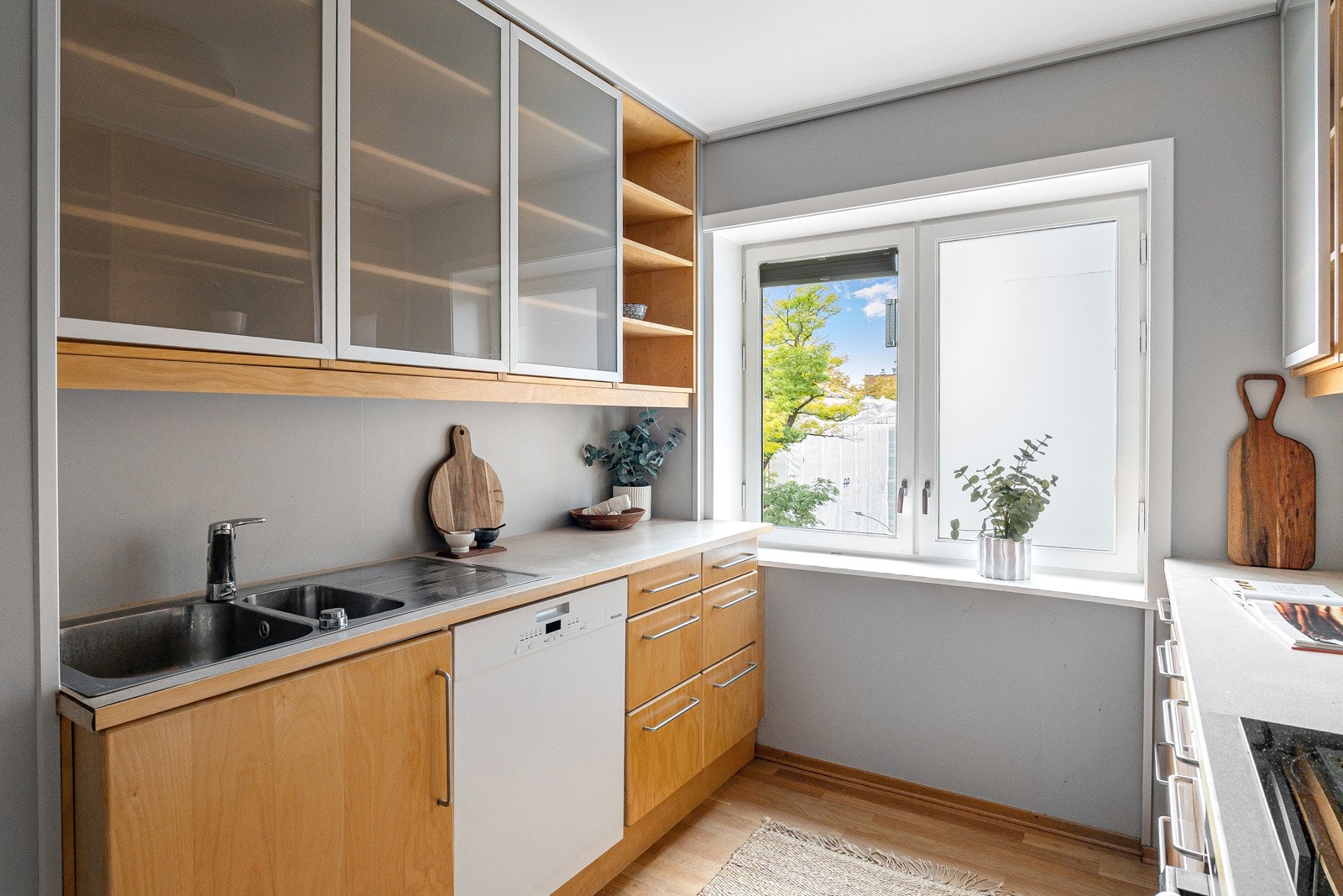 Kjøkkenet ligger i separat løsning og har en funksjonell innredning med glatte trefronter og benkeplate i slitesterk laminat. Galleribilde