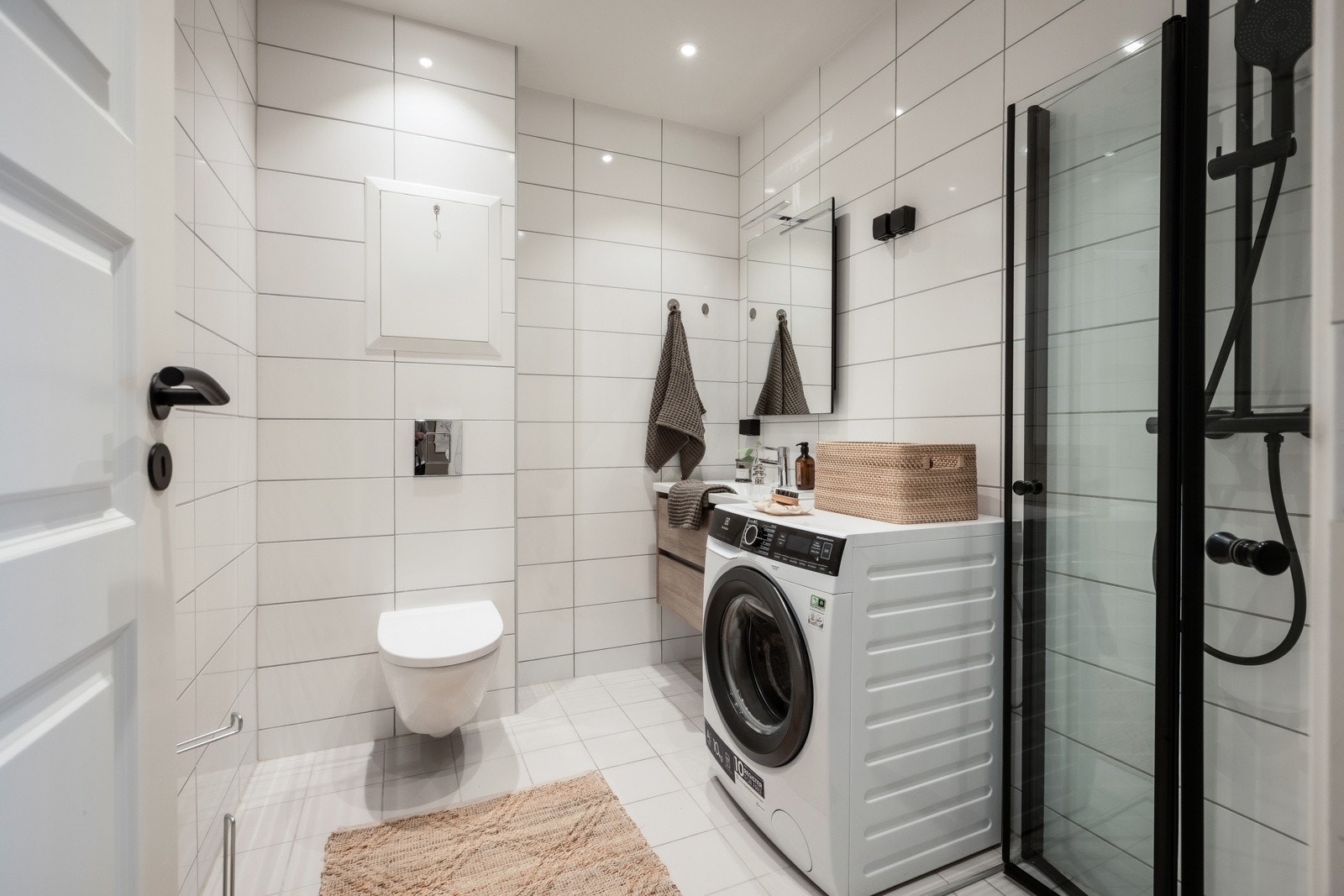 Pent flislagt bad med varmekabler oppgradert i 2020. Badet inneholder dusjnisje med innfellbare glassdører, vegghengt toalett og heldekkende servant med skuffer under, samt vaskemaskin. Galleribilde