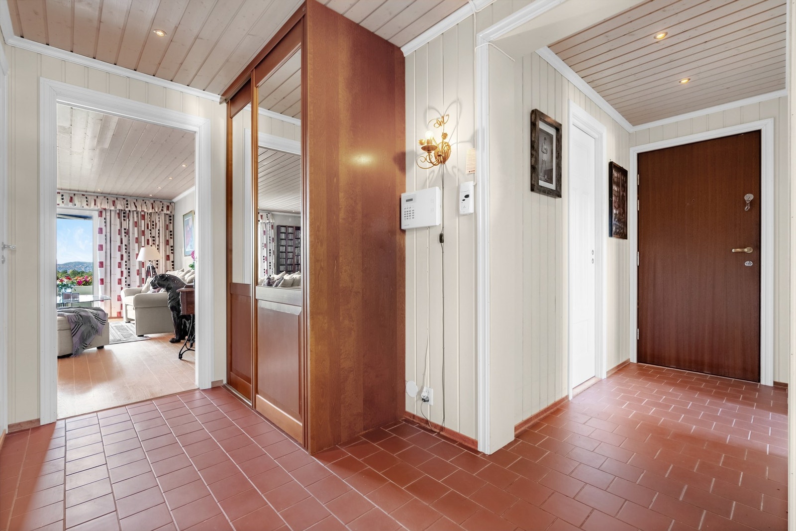 Innbydende entré med flislagt gulv, malte panelvegger og moderne belysning fra downlights i himling. Galleribilde