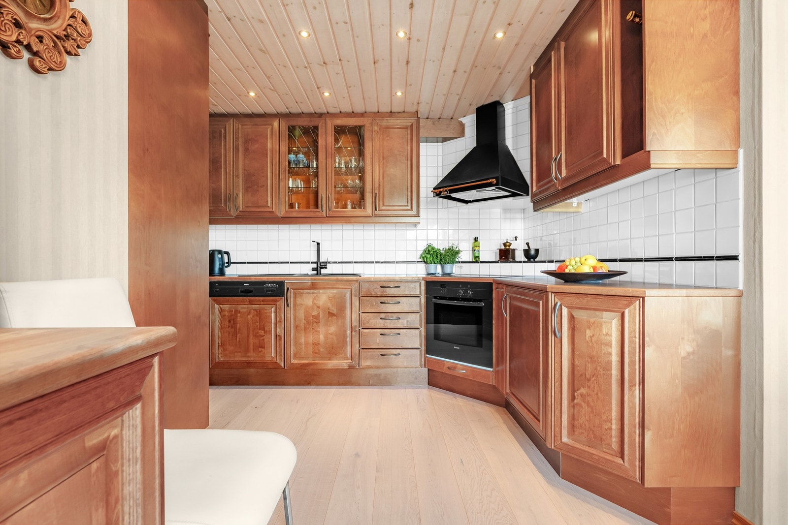 Kjøkkeninnredningen består av profilerte skapfronter og vitrinedører i heltre. Galleribilde