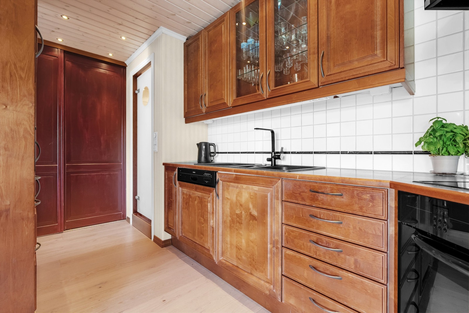 I enden av kjøkkenet er det en praktisk vaskeromnisje bak skyvedør. Galleribilde