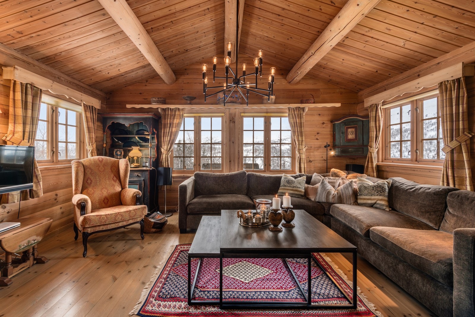 Tømmerveggene omslutter deg, peisen spraker, og du kan synke ned i myke møbler Galleribilde