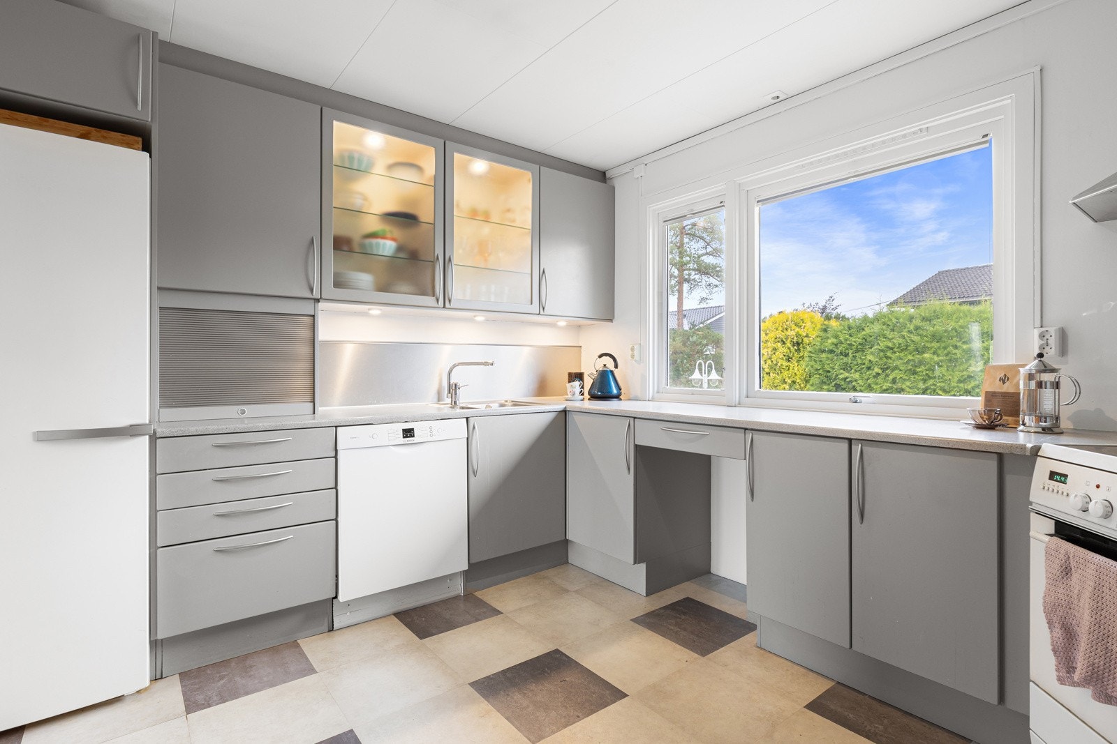 Lyst og praktisk kjøkken med vindu mot gårdsplass. Galleribilde