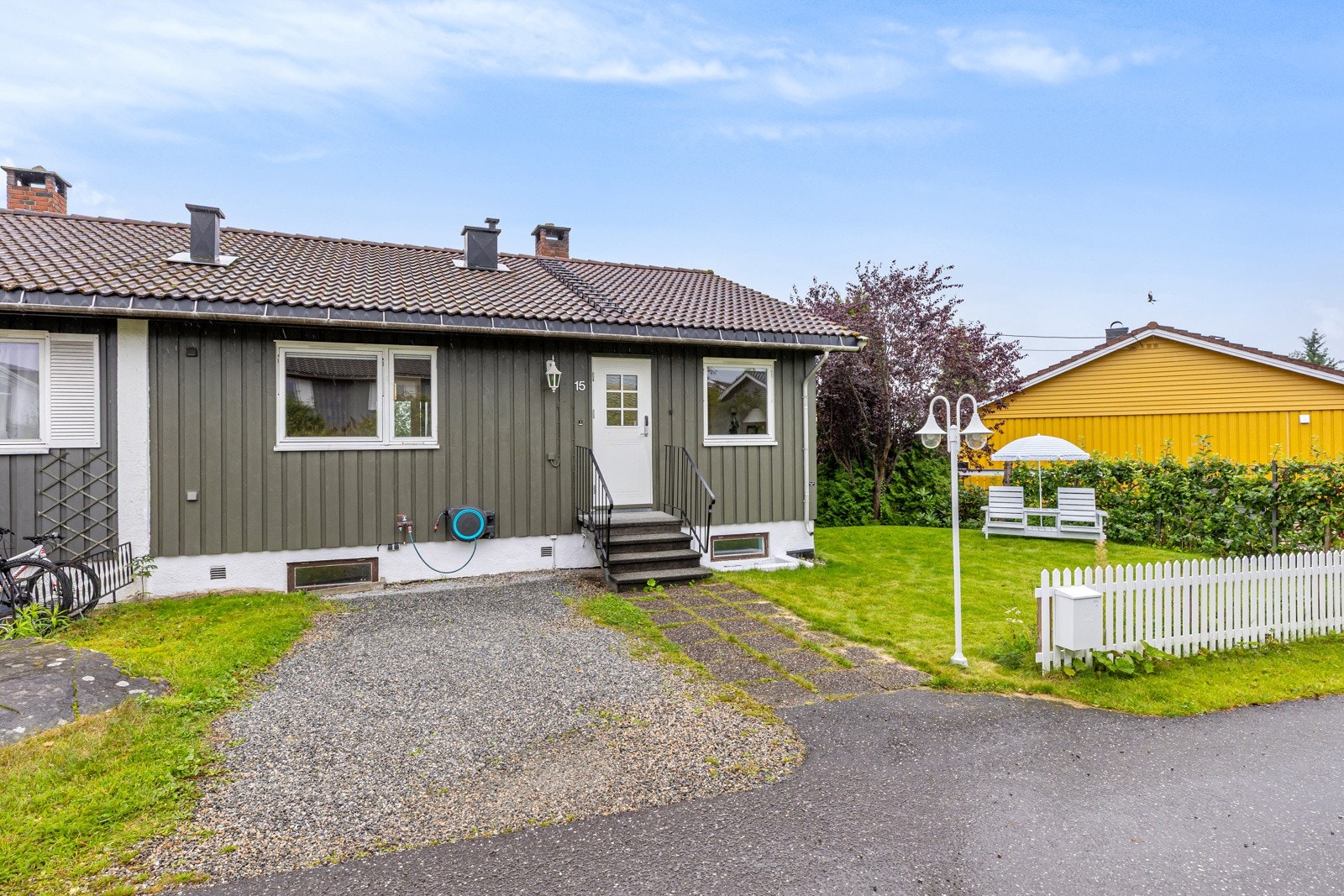 Fasade mot nordvest med biloppstillingsplass og opplegg for elbil-lader. Det er garasjeplass i umiddelbar nærhet. Galleribilde