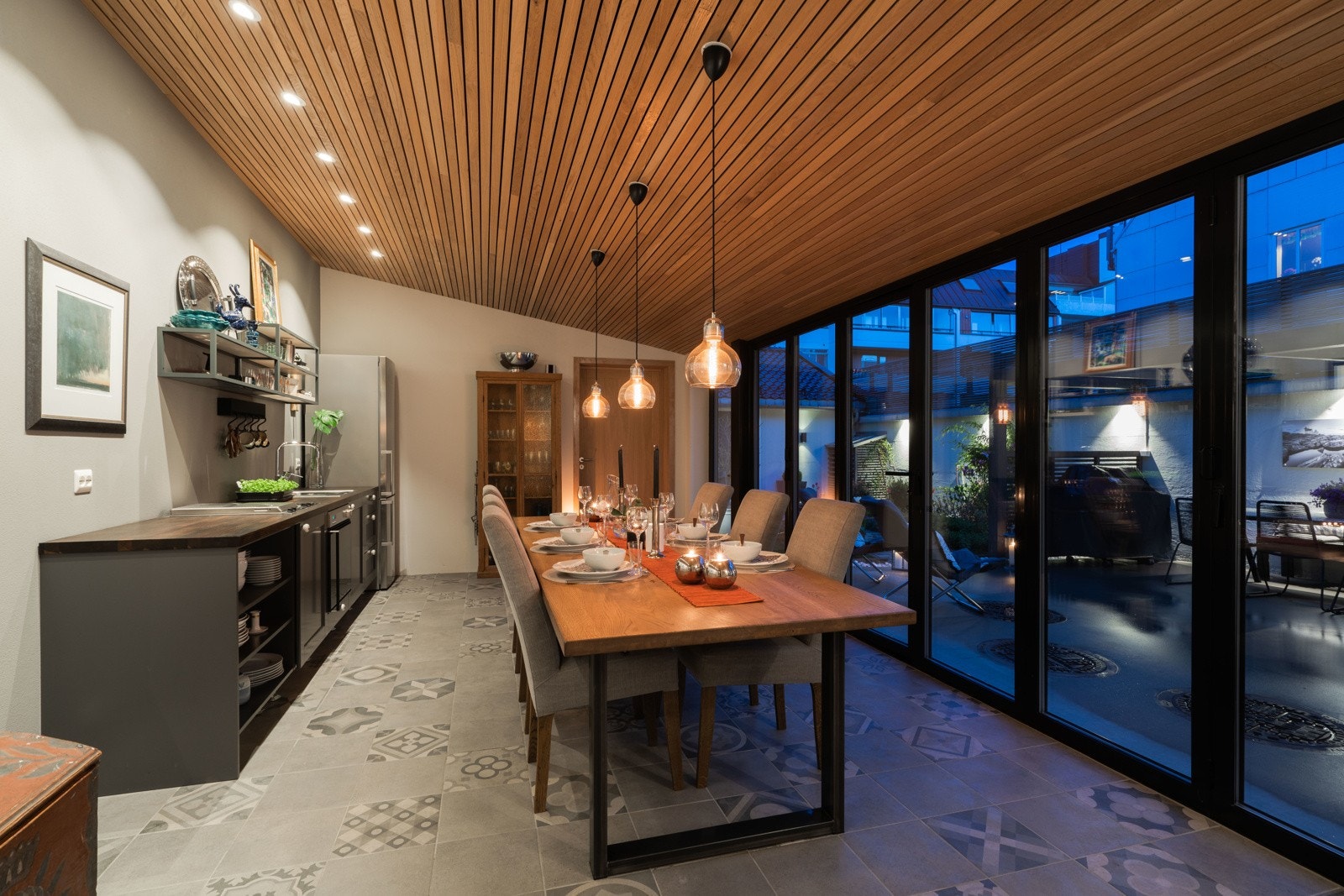 Kveldsstemning med langbord og åpent ut til hagen Galleribilde