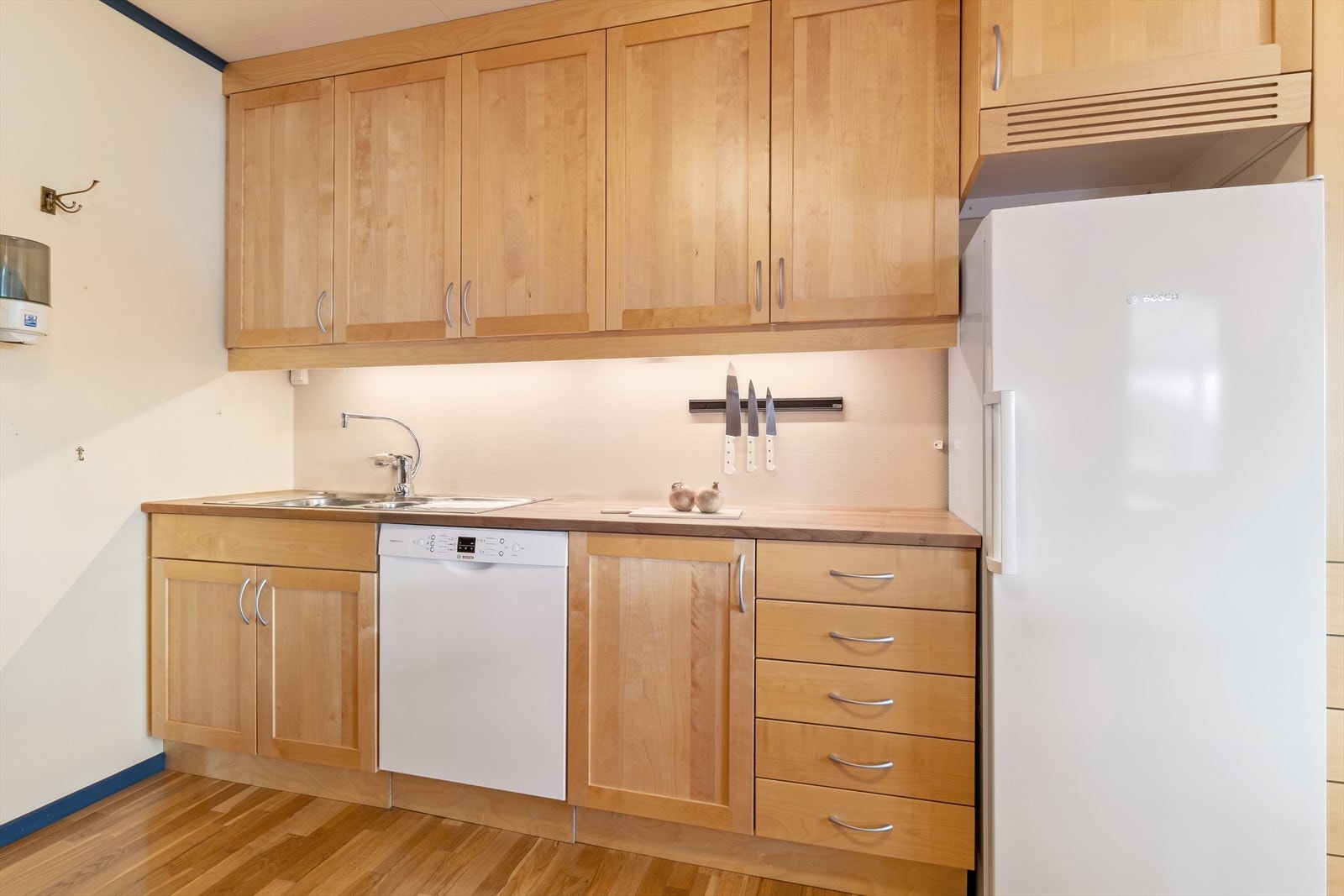 Overskap til himling og profilerte frontar i lakkert bjørk, samt benkeplate i heiltre kirsebær. Galleribilde