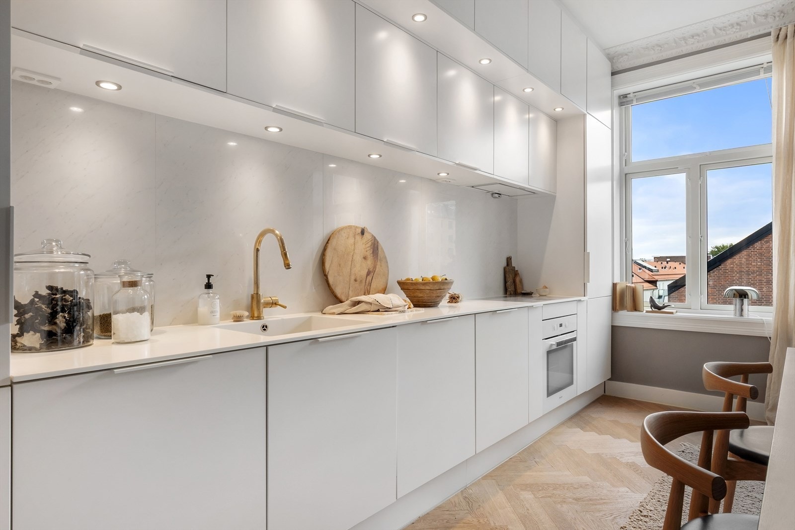 Slette fronter, belysning under overskap, fliser på vegg og Corian benkeplate. Galleribilde