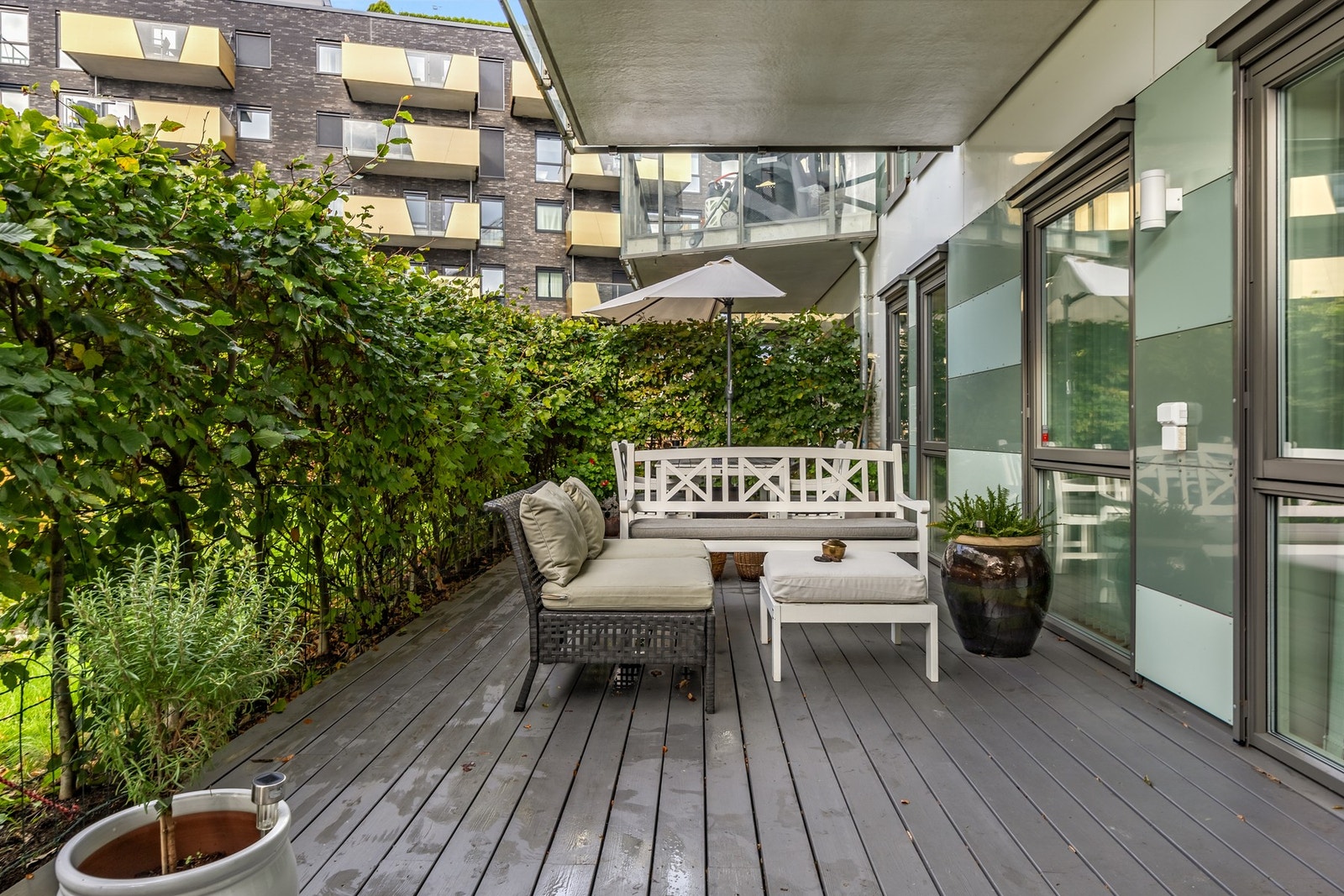 En frodig bøkehekk gjør terrassen meget privat og trivelig. Plass for både spisegruppe og sofagruppe. Galleribilde