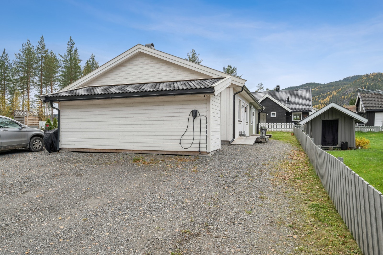 Parkering på felles gårdsplass med elbil-lader. Galleribilde