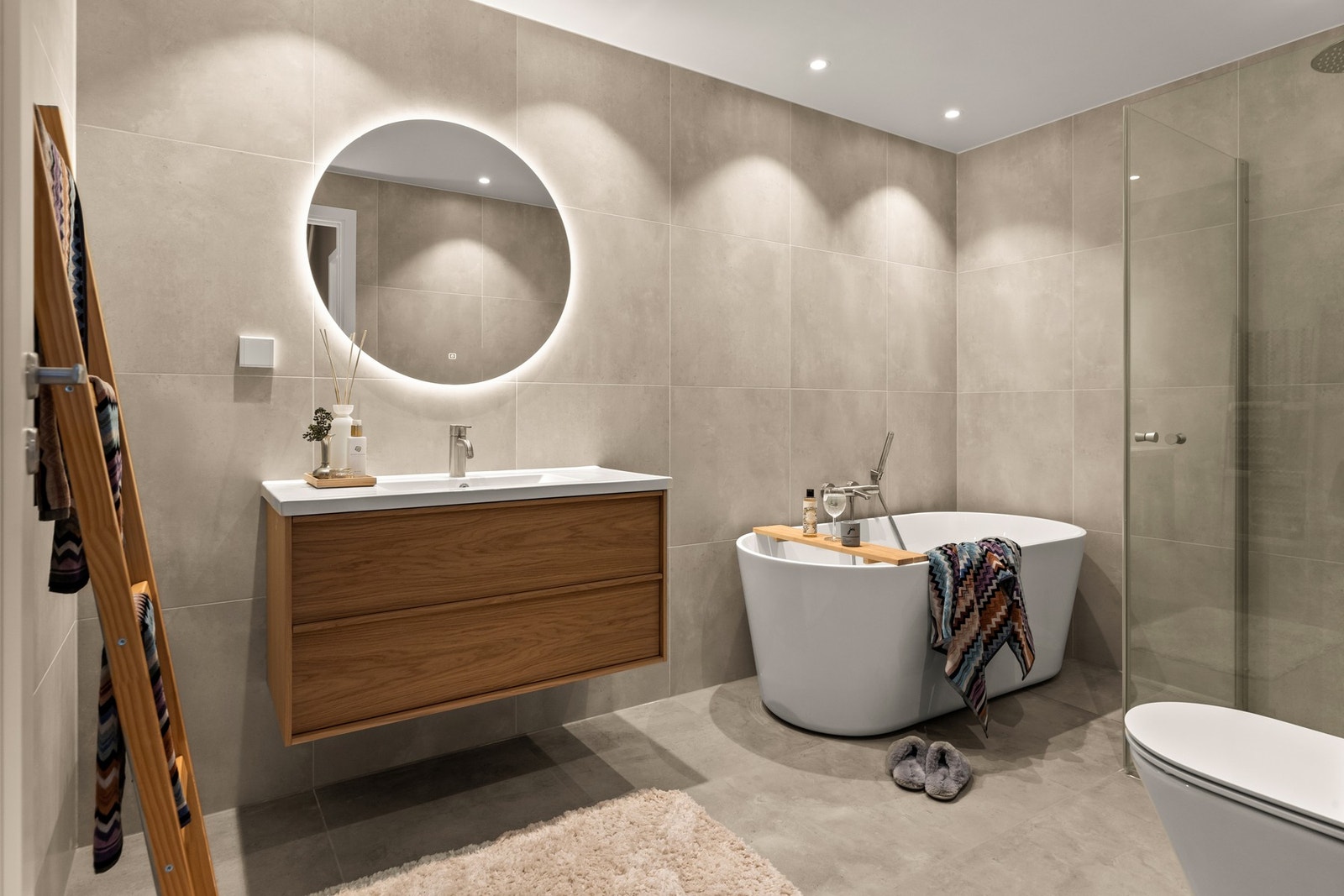 Felles baderom nede med Home eik vaskeservant, badekar og dusjnisje. Flotte fliser og gjennomført stil. Galleribilde