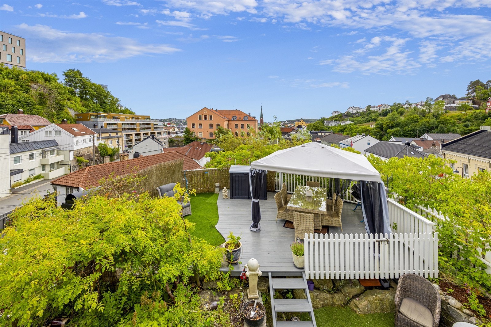 Uteplassen bak boligen er opparbeidet med terrasser og diverse planter og blomster. Hyggelig "oase" midt i sentrum med fin utsikt. Galleribilde