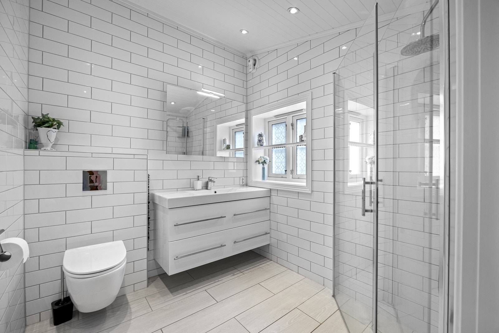 Flislagt bad med dusjhjørne, veggehengt servant og toalett Galleribilde