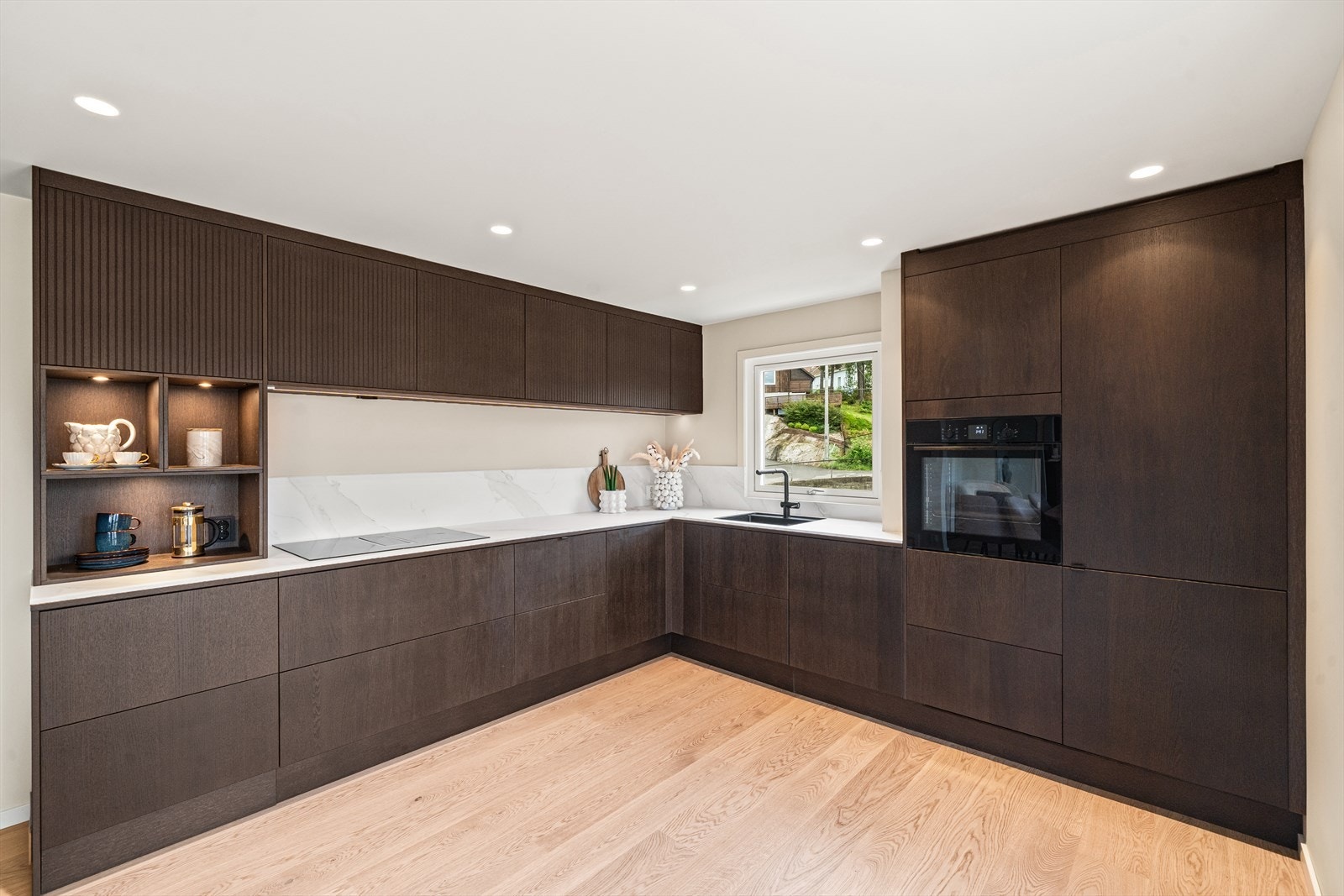 Stuen i åpen løsning med kjøkkenet skaper en sosial sone hvor også kokken holdes med selskap. Galleribilde