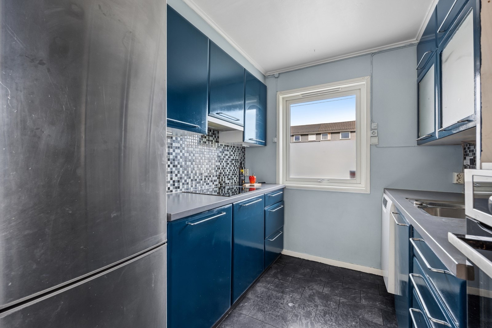 Innredning med malte slette fronter, laminert benkeplate og oppvaskkum. Galleribilde