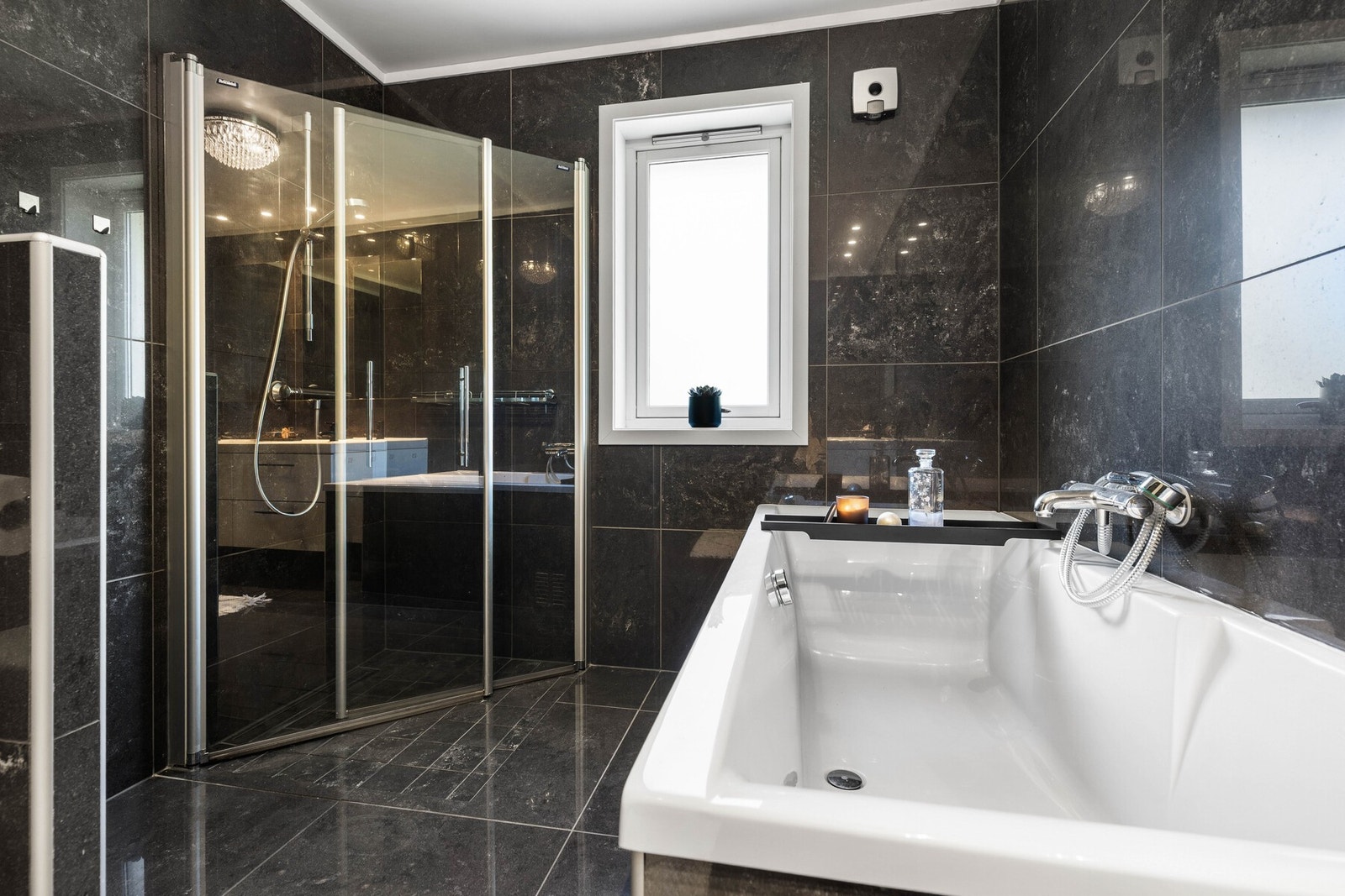 Dusjnisje med glassvegger som gir rommet et rent uttrykk, og i tillegg er det et badekar som gir rommet en ekstra touch av spa og velvære. Galleribilde