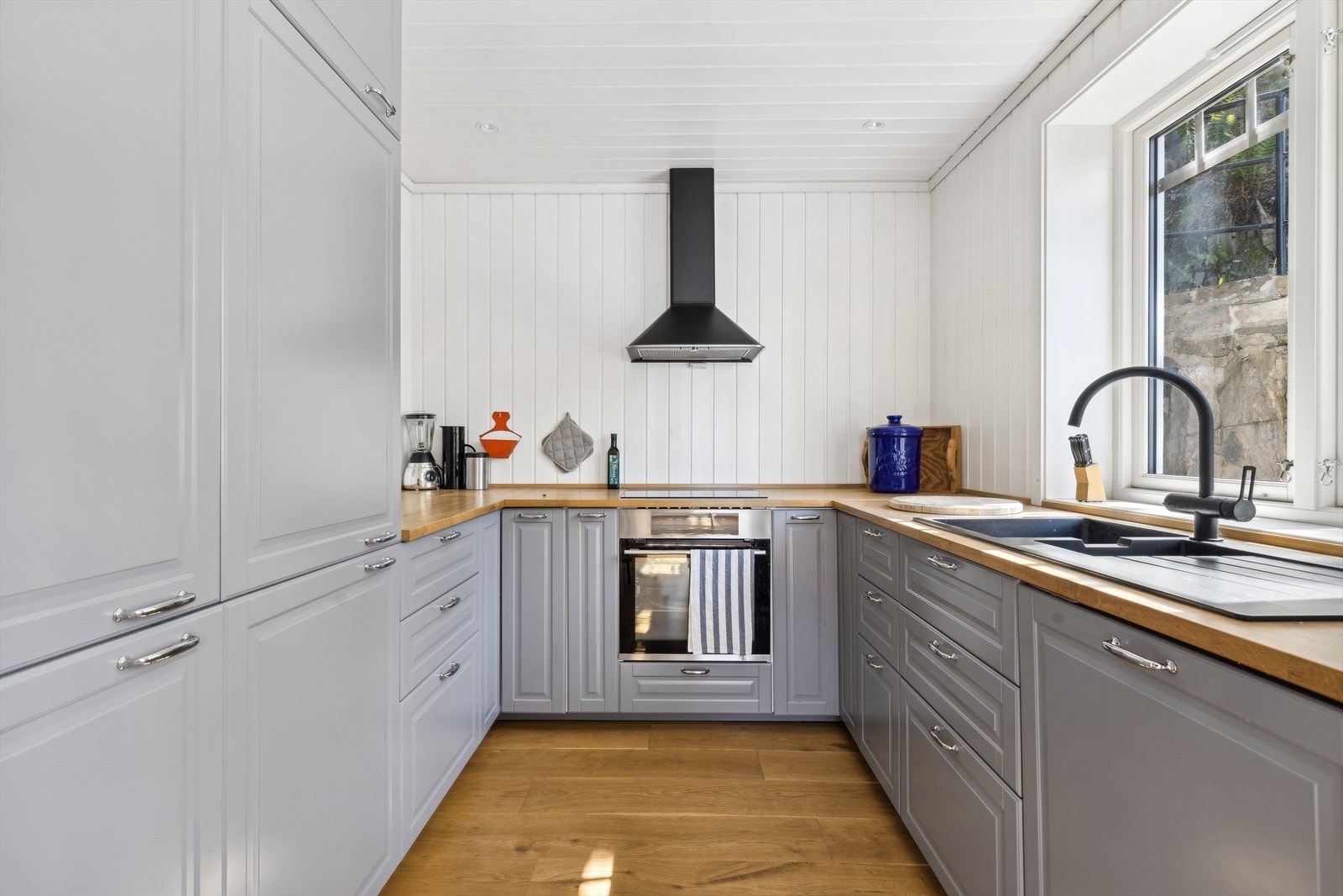 Nyere og stilrent kjøkken med integrerte hvitevarer og heltre benkeplate. Galleribilde