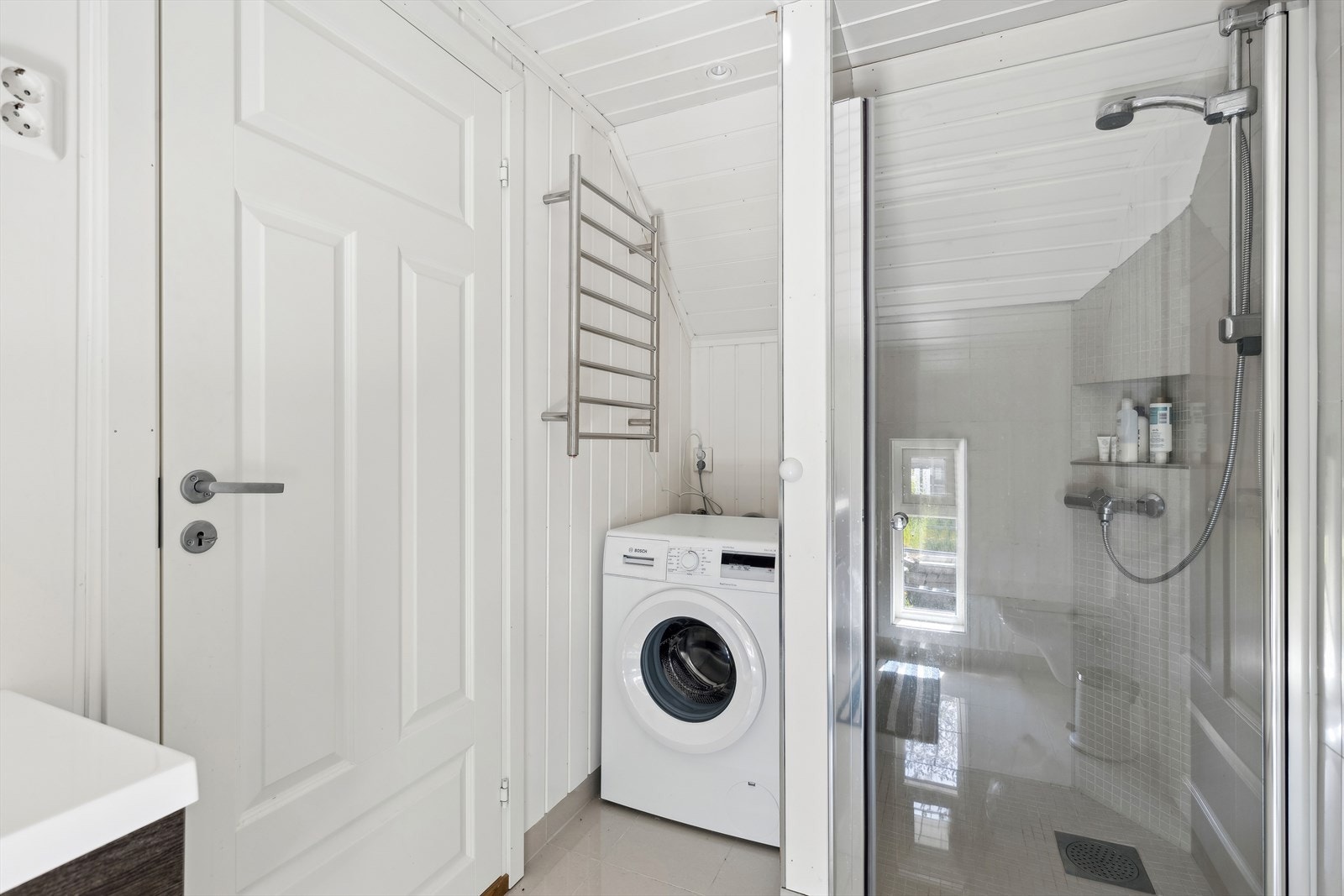 Dette er et moderne bad med gulvvarme, dusjhjørne med glassdører og vegghengt toalett. Galleribilde