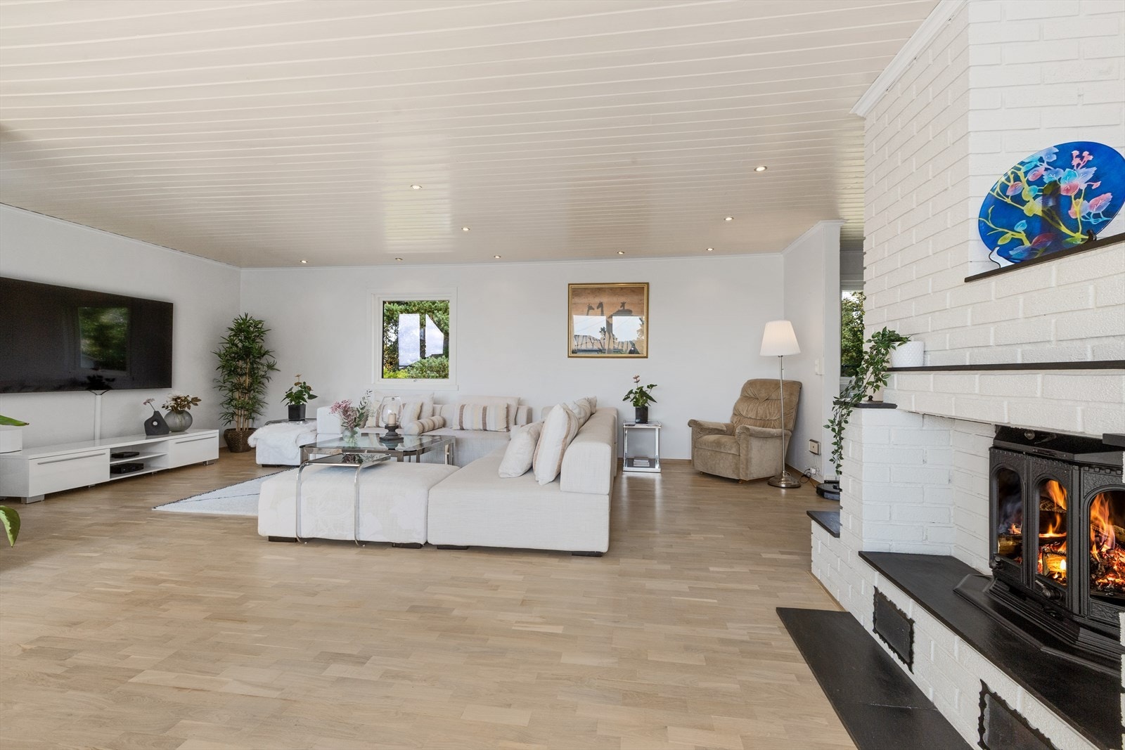 Stue og psisestue har peisovn og utgang til terrasse Galleribilde