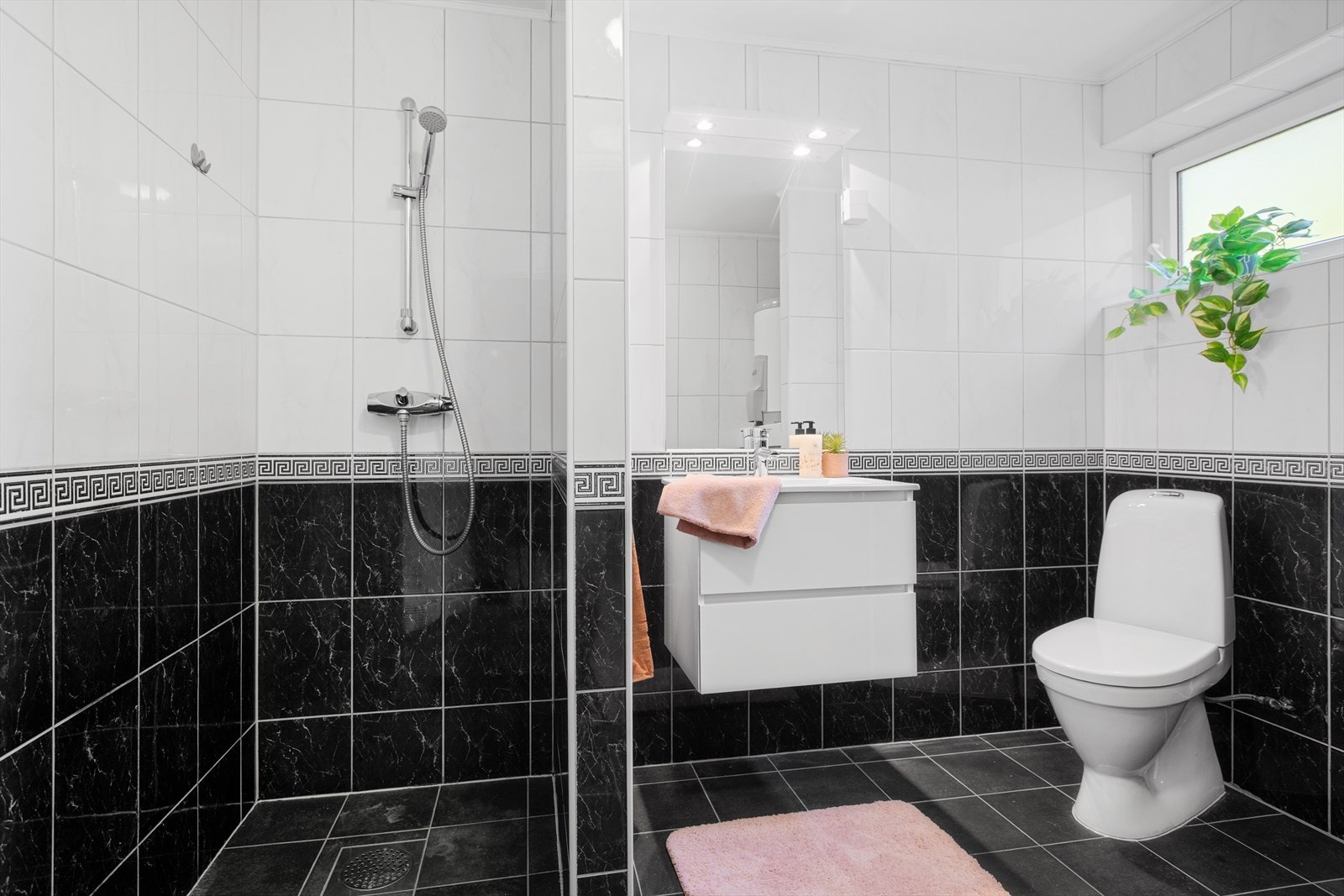 Bad i hybelen er praktisk med dusjnisje, servant, toalett og opplegg for vaskemaskin Galleribilde