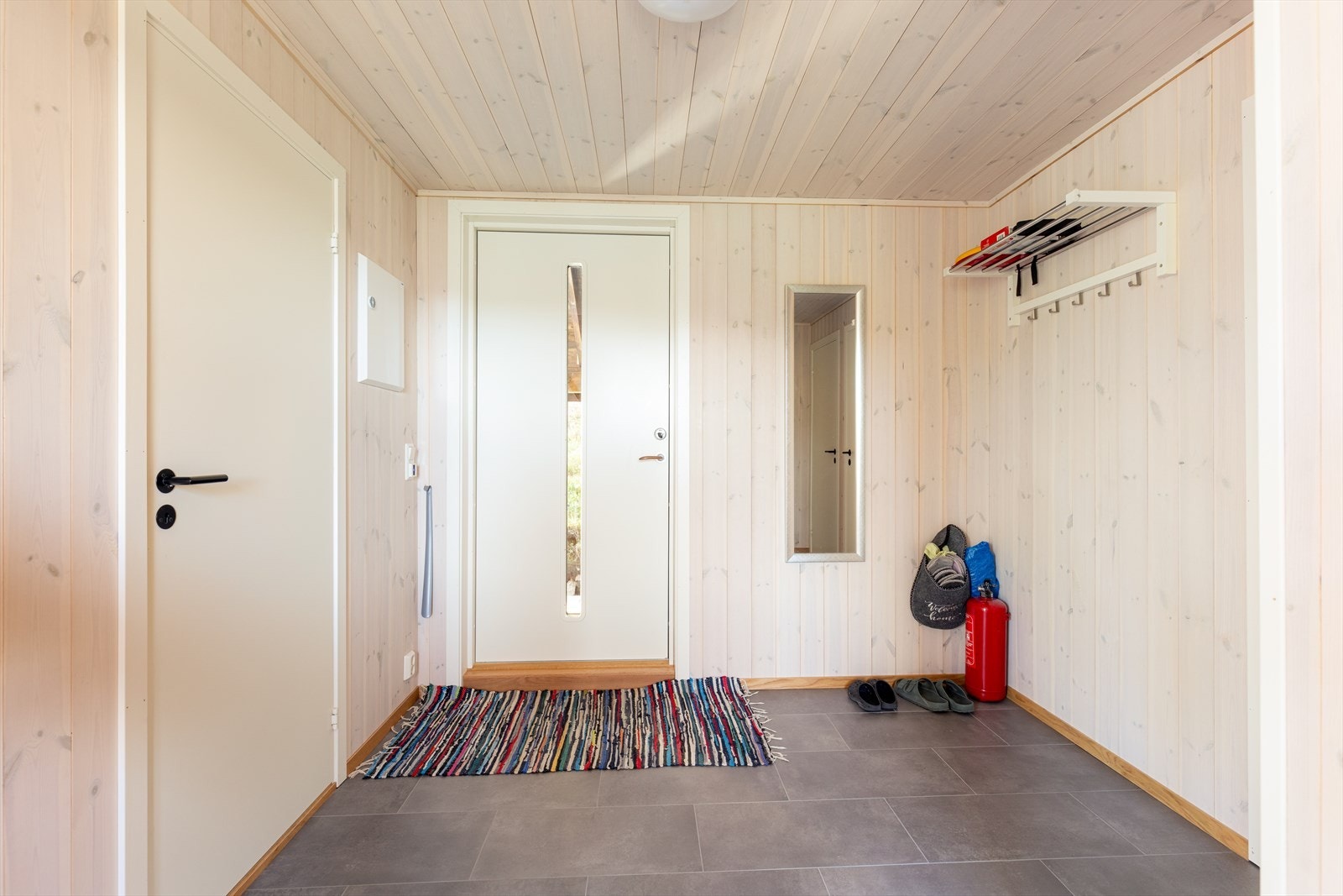 Hytta har en lys og romslig entré som ønsker velkommen inn! Her er det god plass til å sette fra seg sko og henge fra seg yttertøy. Galleribilde