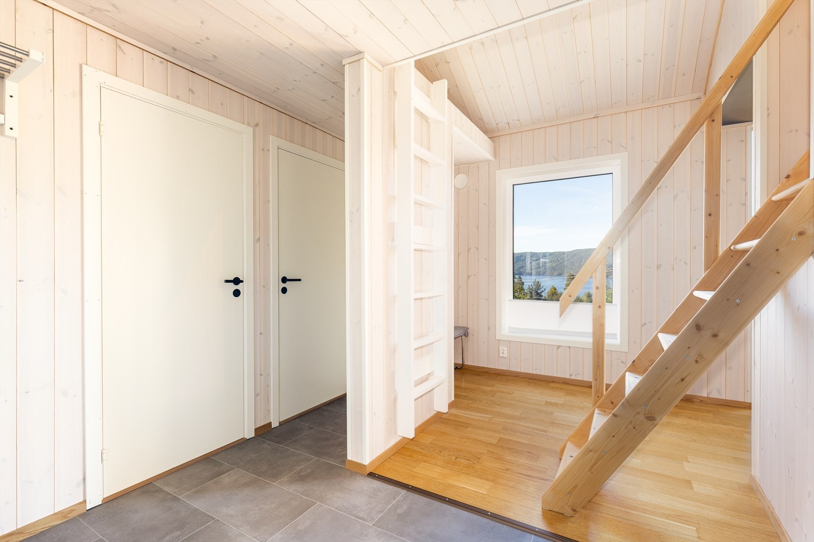 Gang med trapp opp til hems. Her er det også stige opp til praktisk oppbevaringsplass. Galleribilde