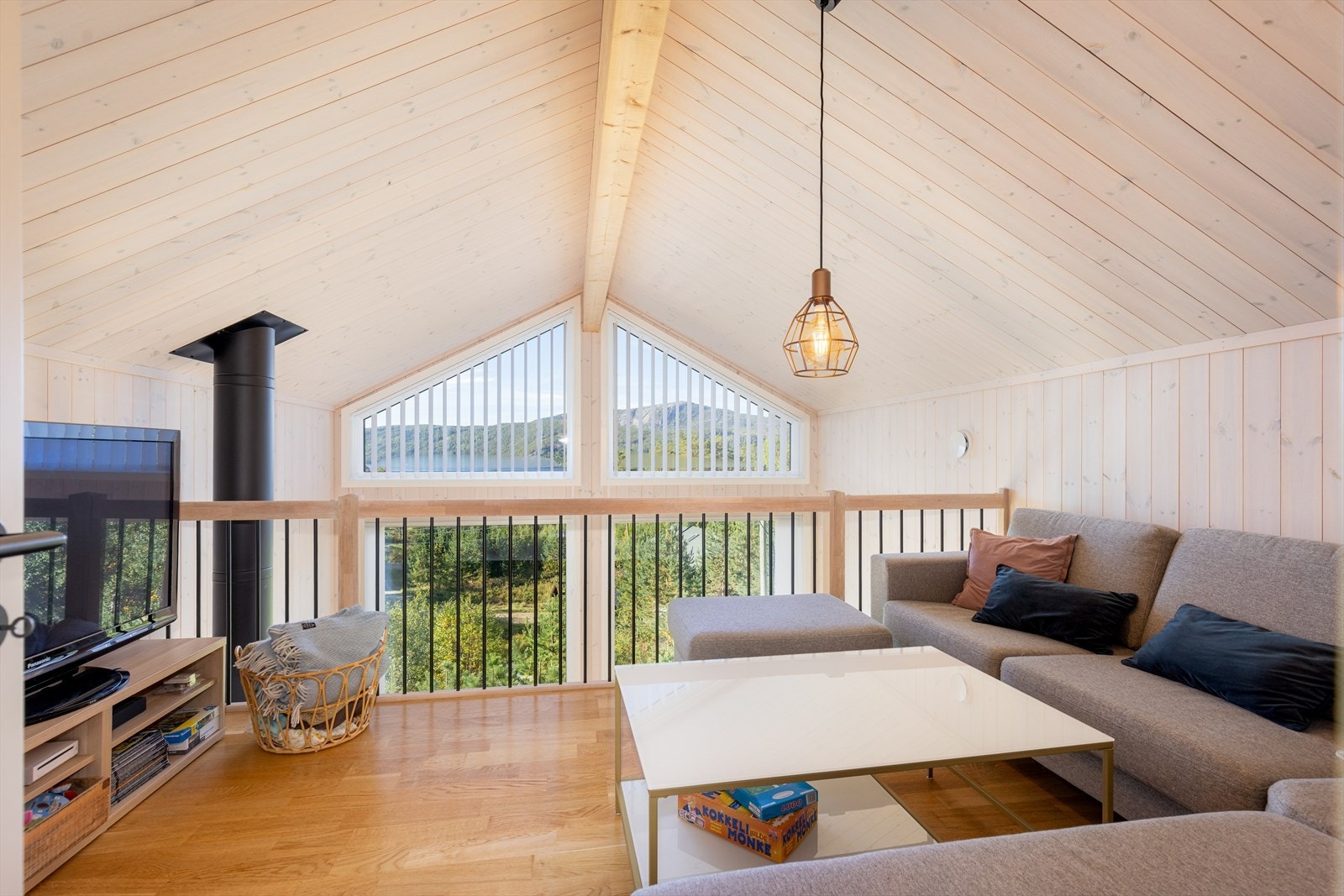 Koselig stue med plass for sofa og mediemøblement. Her er det god takhøyde og også her kan man nyte den fine utsikten. Galleribilde