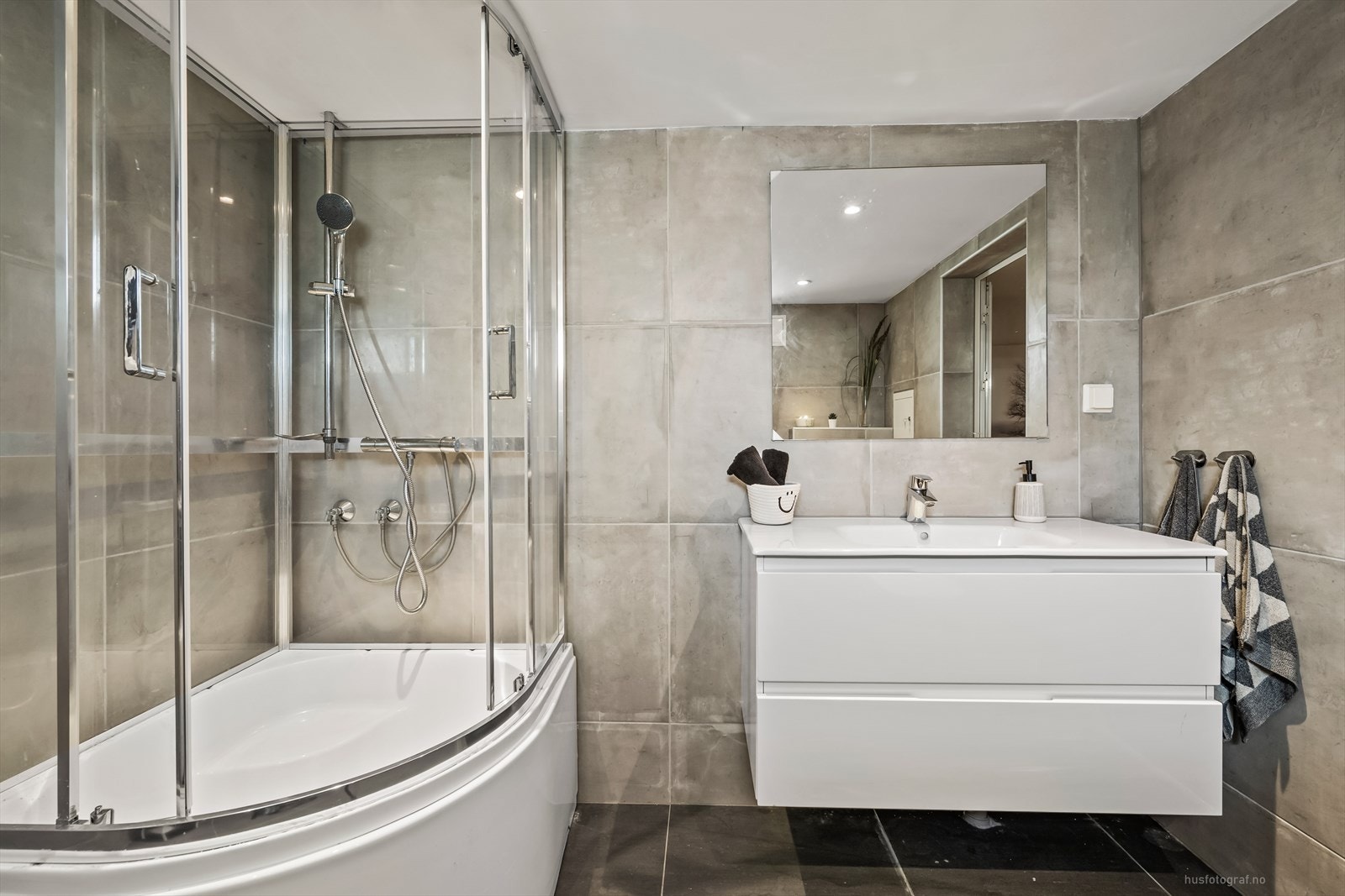 Videre er badet utstyrt med vegghengt toalett og dusjkabinett med bademulighet. Galleribilde