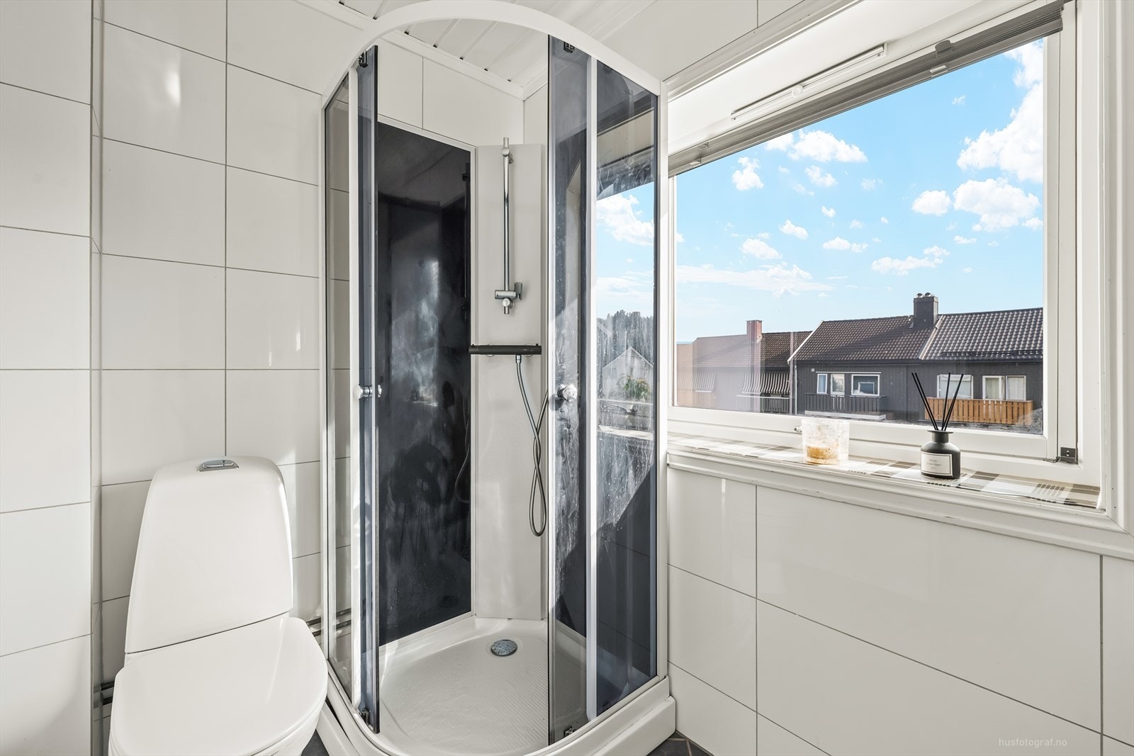 Baderomsinnredningen har heldekkende nedfelt servant, rundt speil med belysning og rom for oppbevaring. Videre er badet utstyrt med toalett og dusjkabinett. Galleribilde