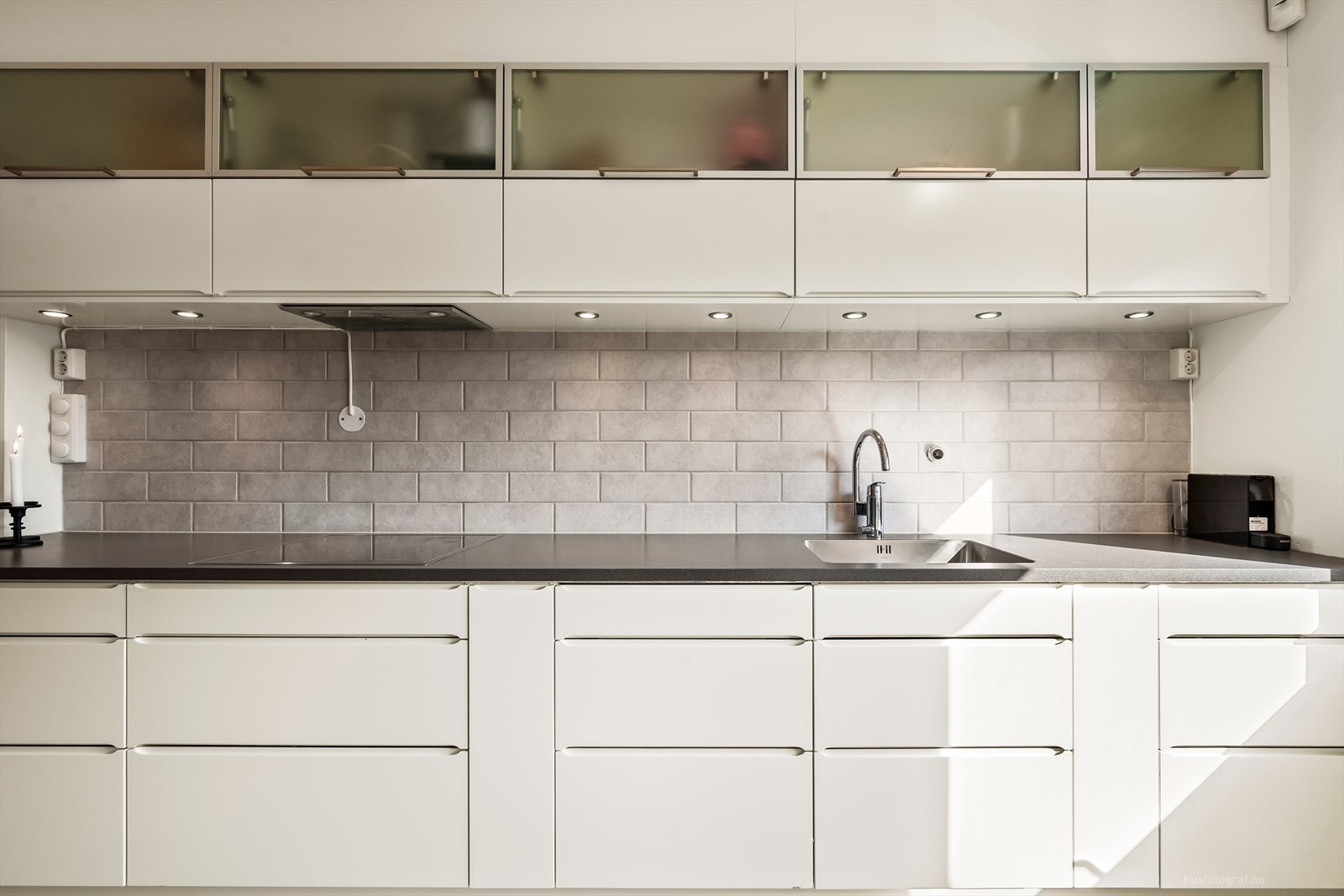 Det moderne kjøkkenet har rikelig med skapplass og benkeplass, noe som gir både praktisk oppbevaring og god arbeidsflate til matlaging. Galleribilde