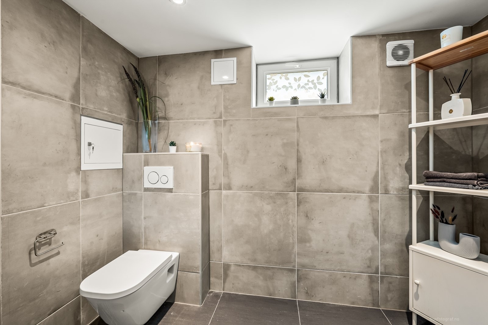 Badet har store rustikke fliser på vegg og varmekabler i gulv. Galleribilde