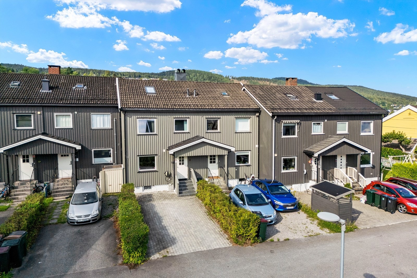 Parkering forekommer i gårdsplass med belegningsstein. Det er montert elbillader. Galleribilde