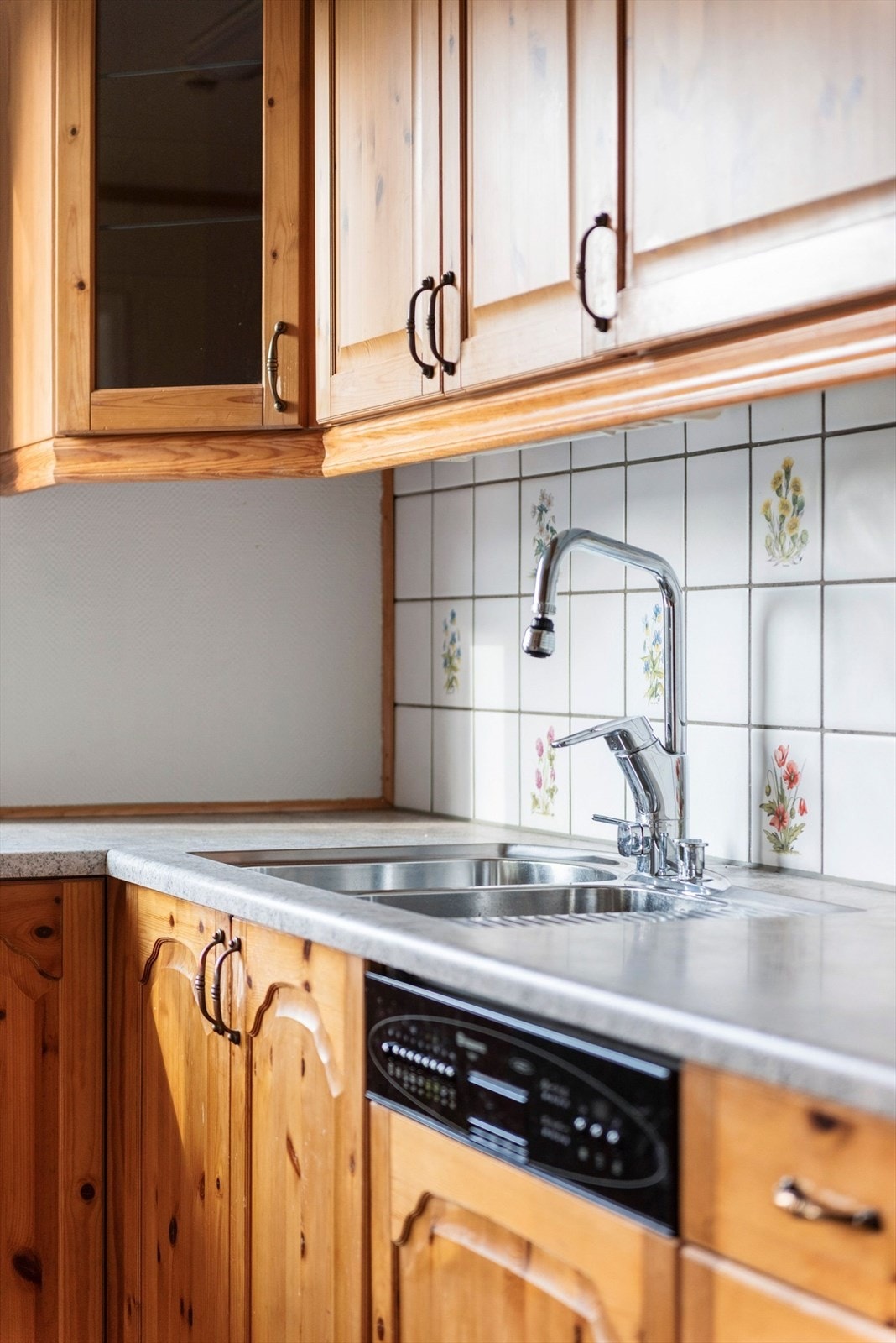 Nedfelt oppvaskkum med ett-greps kjøkkenarmatur. Benkeskapsbelysning og stikkontakter over kjøkkenbenk. Galleribilde