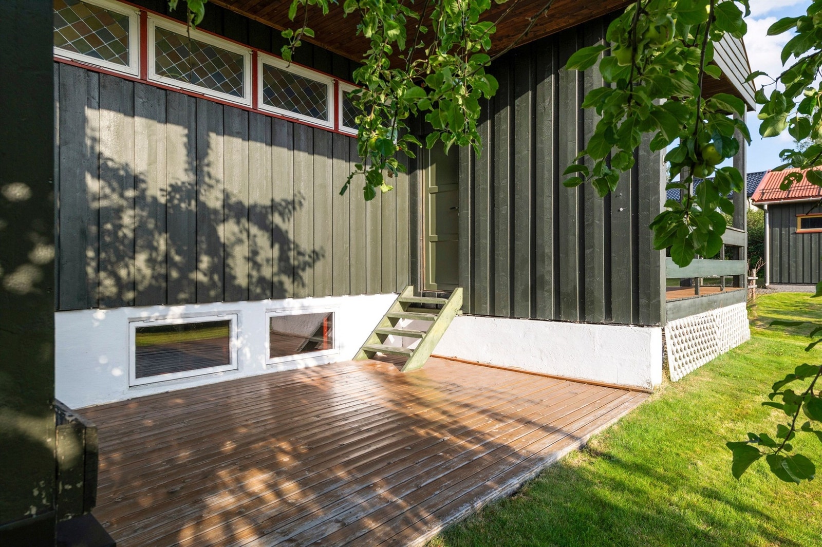 Tilgang fra terrasse til vestvendt markterrasse på 12 m2. Terrasse i trekonstruksjoner. Galleribilde