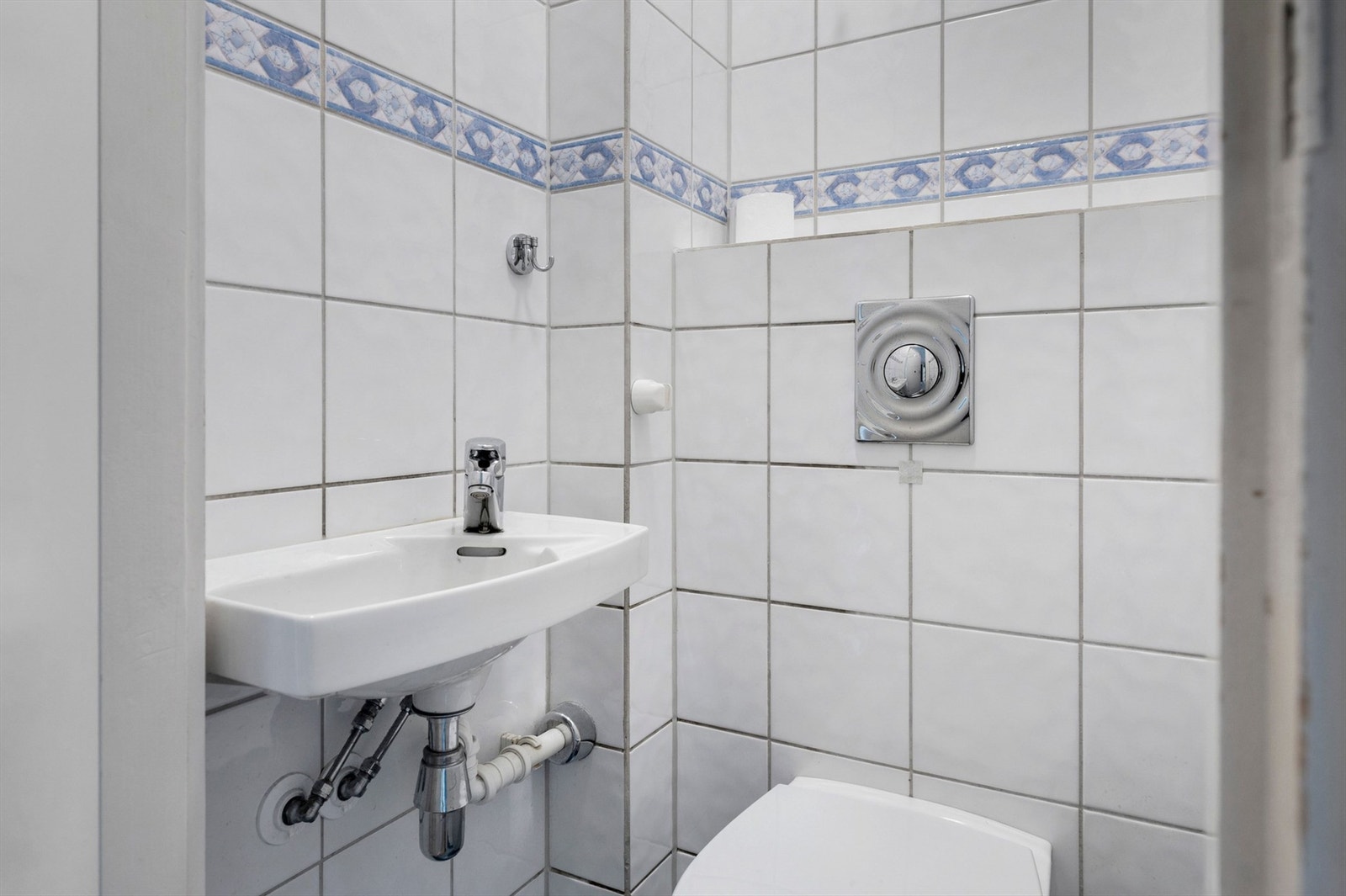 Vegghengt servant med ett-greps armatur. Vegghengt toalett. Naturlig avtrekksventil på vegg. Galleribilde