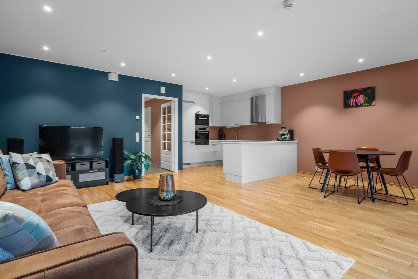 Stuen er naturlig inndelt i ulike soner, og det passer utmerket å innrede med spisebord ved kjøkkeninnredningen. Galleribilde