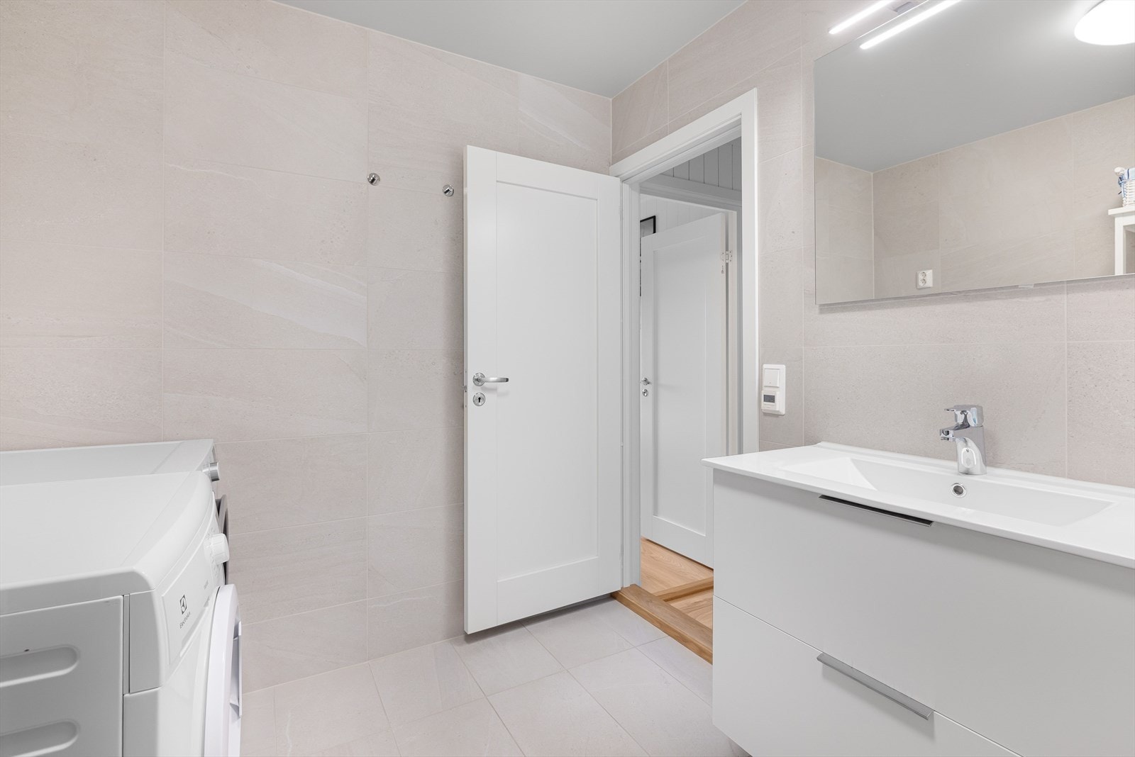 Det er flislagt og har elektrisk gulvvarme. Opplegg for vaskemaksin og tørketrommel. Galleribilde