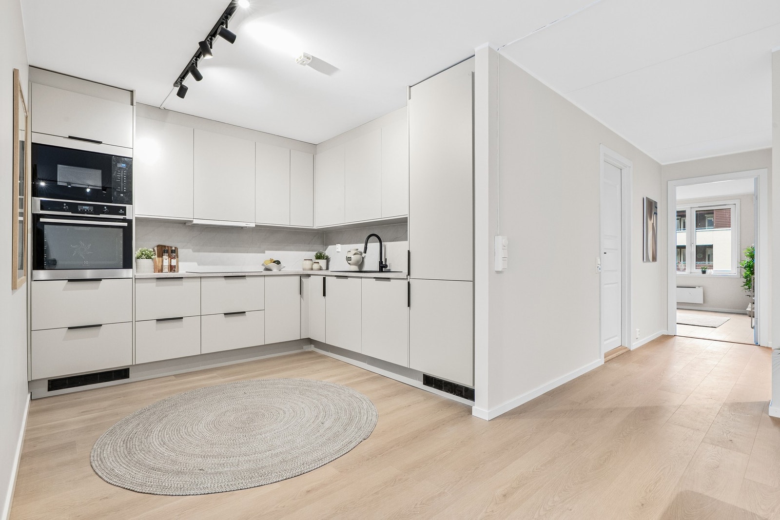 Moderne, takhøy kjøkkeninnredning i eget hjørne m/integrerte hvitevarer. Galleribilde