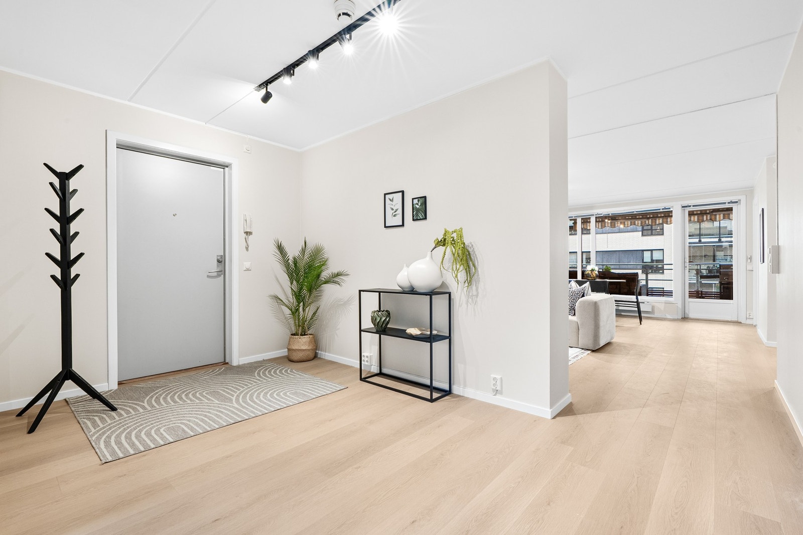 Romslig og flott entré med nytt laminatgulv fra 2025 og glatte, malte veggflater i nøytrale toner. Galleribilde