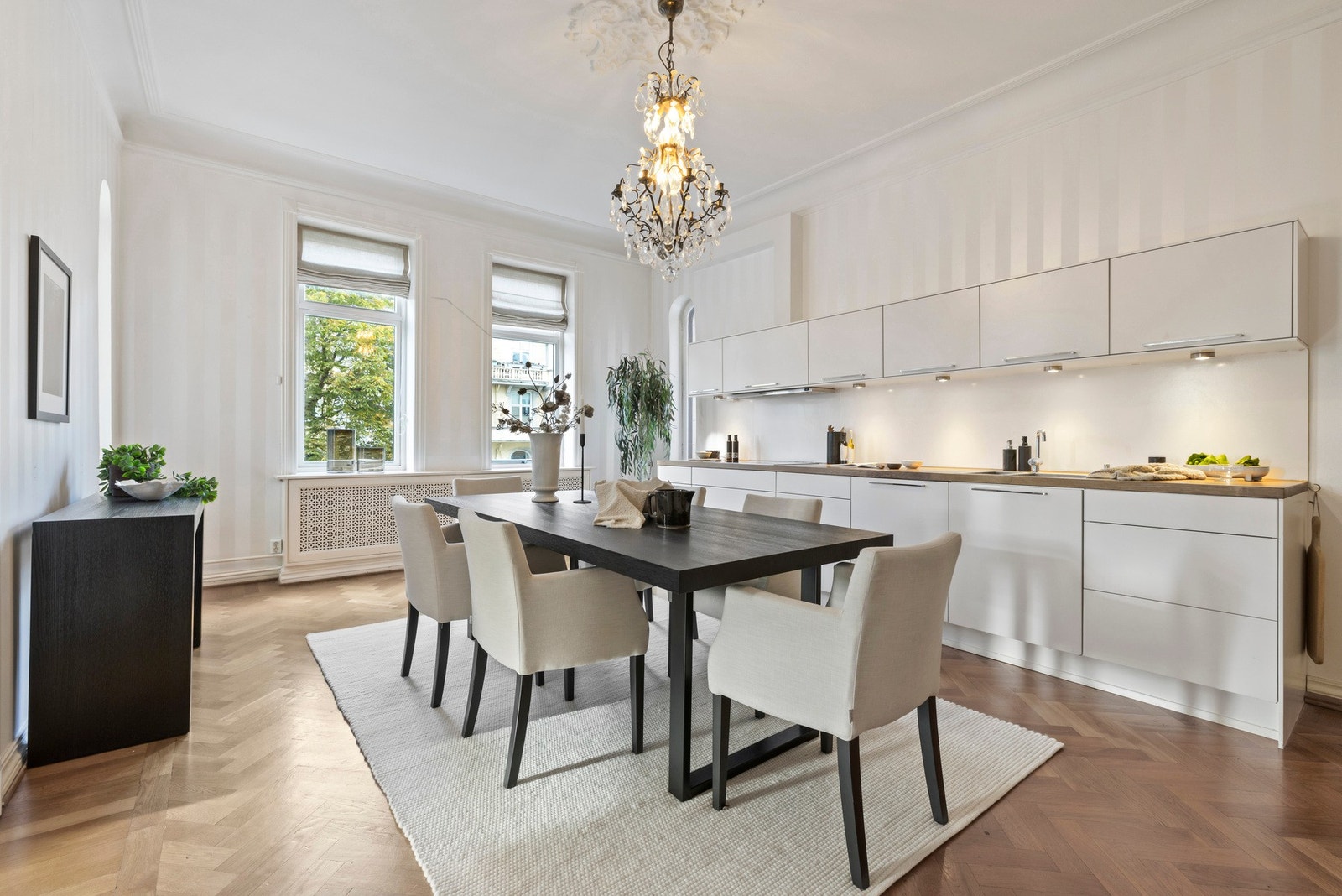 Kjøkkenet er stort, lyst og luftig, med fiskebensparkett og stripete tapet på veggene.