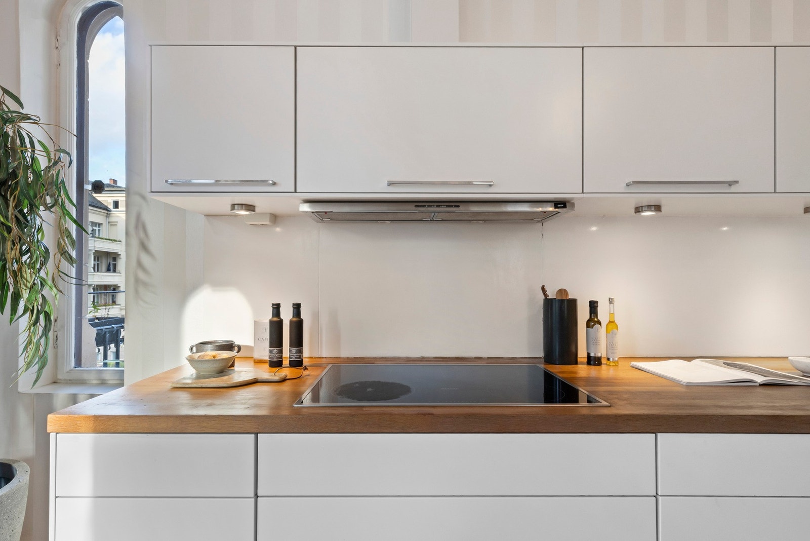 Innredningen har hvite, glatte fronter, store høyskap og dobbel oppvaskkum nedfelt i en delikat benkeplate av tre.