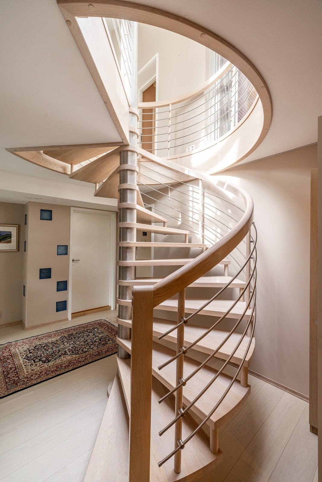 Lekker vindeltrapp med trinn i tre og elegant rekkverk i tre og stål. Galleribilde