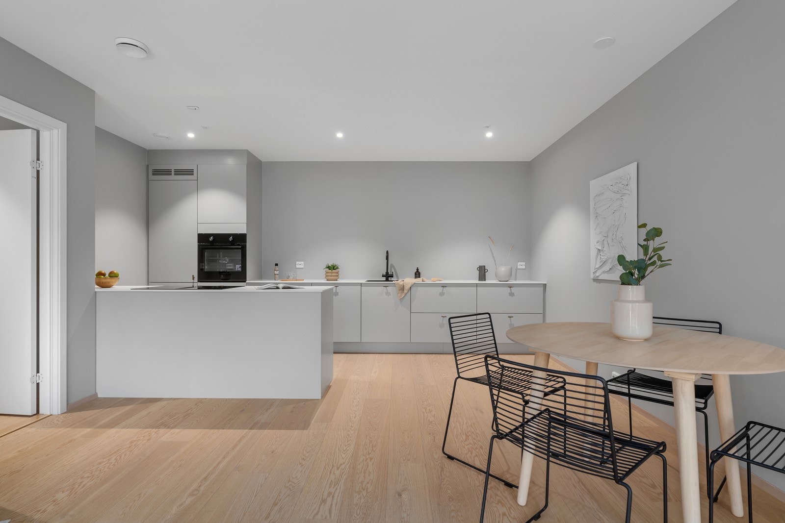 Hjertet i leiligheten er dette stilrene kjøkkenet med øy og god benkeplass. Galleribilde