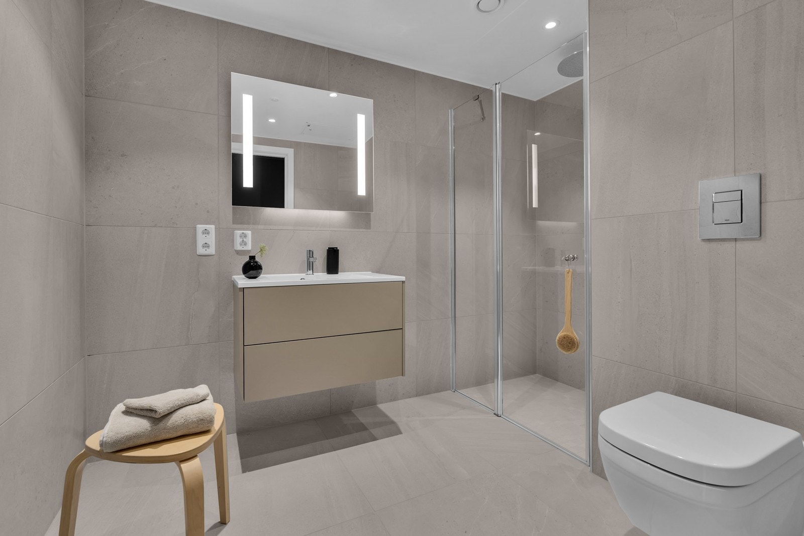 Lekkert bad med toalett, dusjhjørne og servant med skuffeløsning. Galleribilde