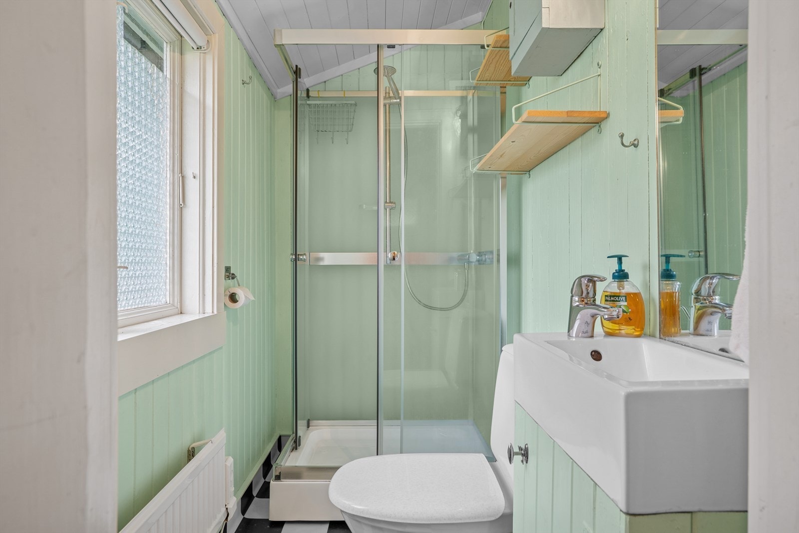 Badet har varmekabler i gulv, innredet med toalett, dusjkabinett, samt baderomsinnredning med servant og speil. Galleribilde