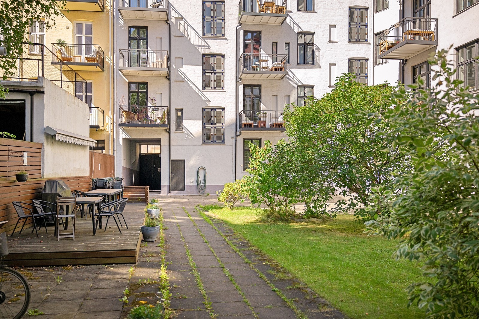 Hyggelig bakgård med sittegrupper og beplantning Galleribilde