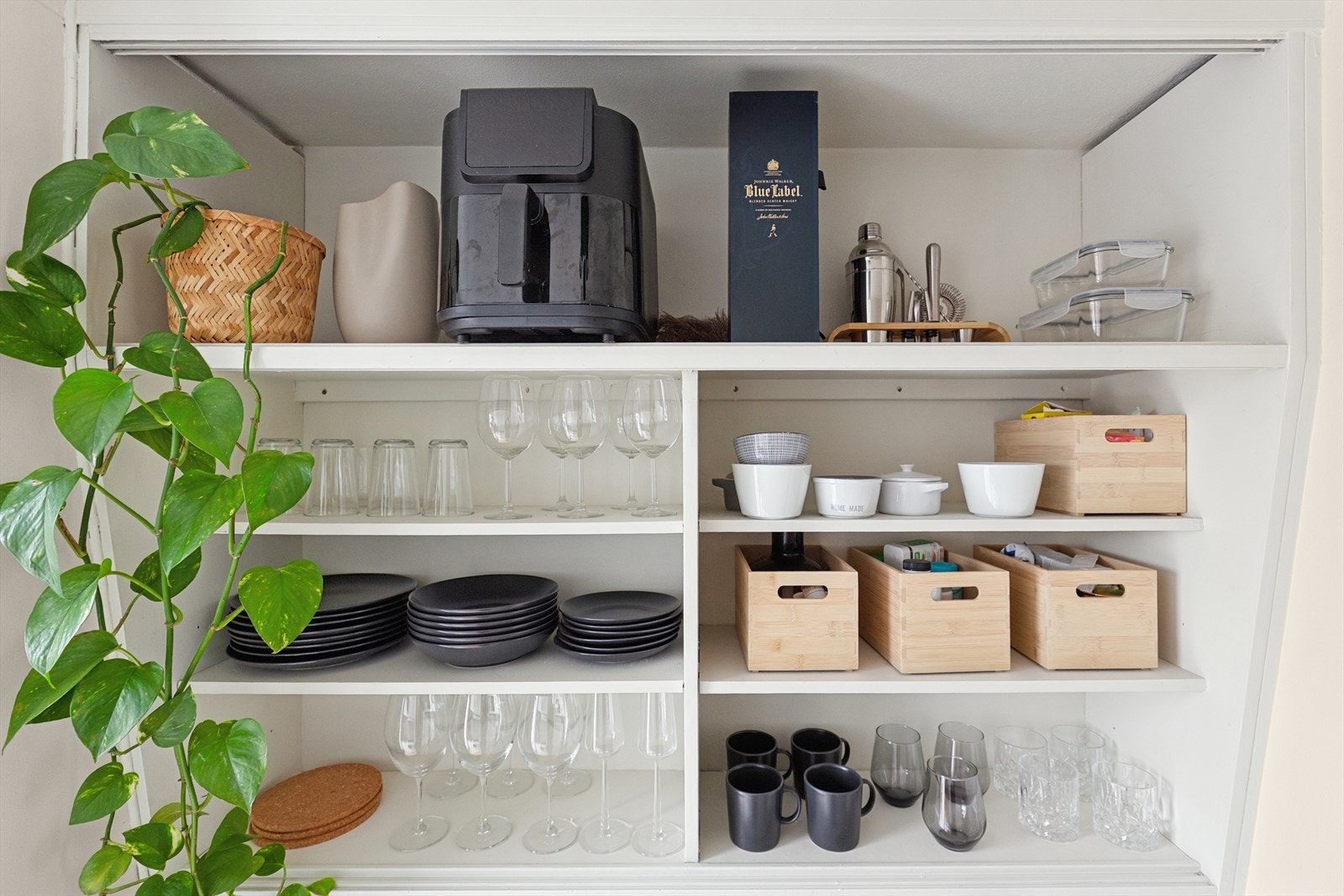 Lyst og funksjonelt kjøkken med rikelig hylleplass både oppbevaring av kopper og kar. Galleribilde