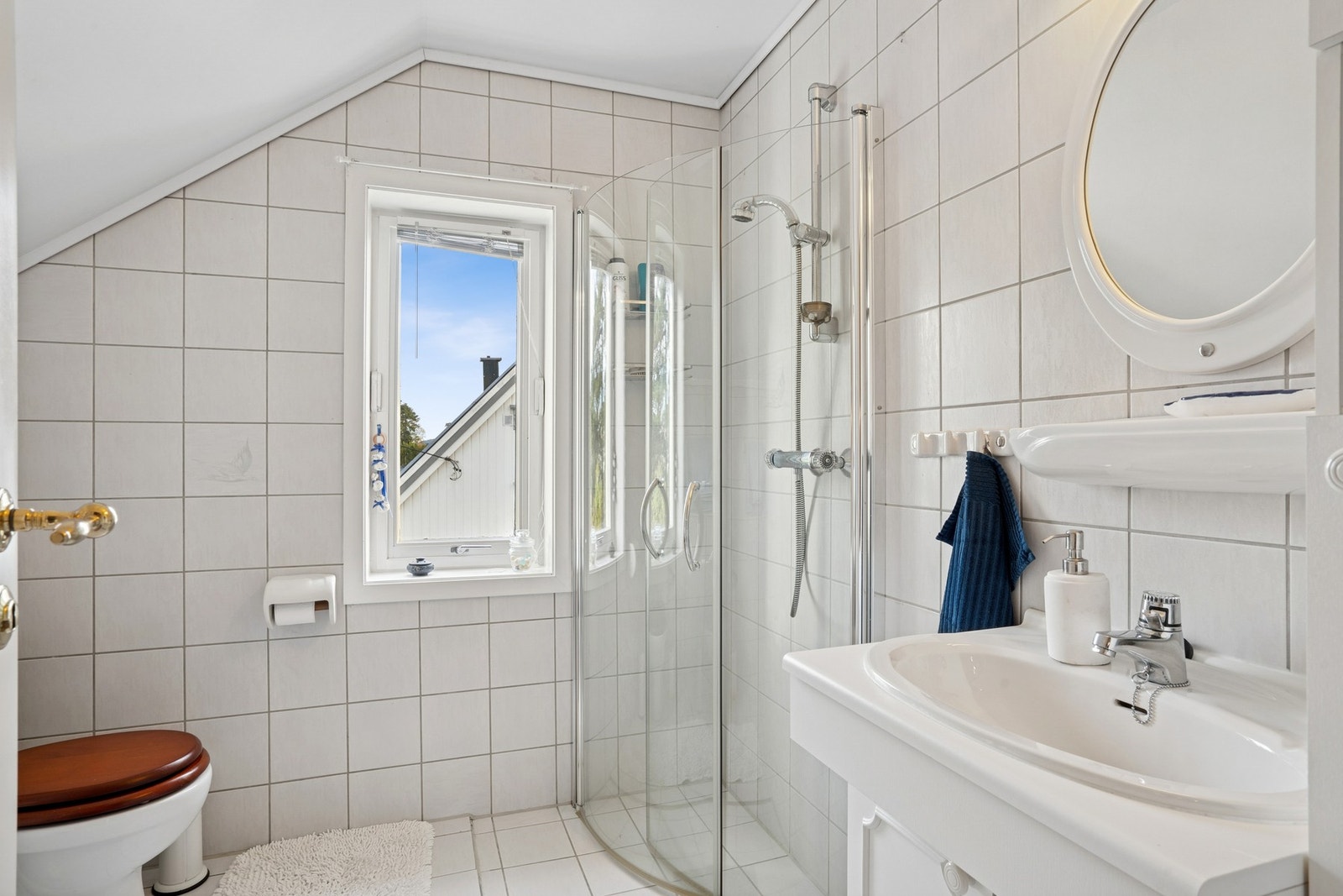 Baderommet i andre etasje byr på flislagte flater med varme i gulv, servantinnredning og dusjhjørne med innfellbare glassdører. Galleribilde