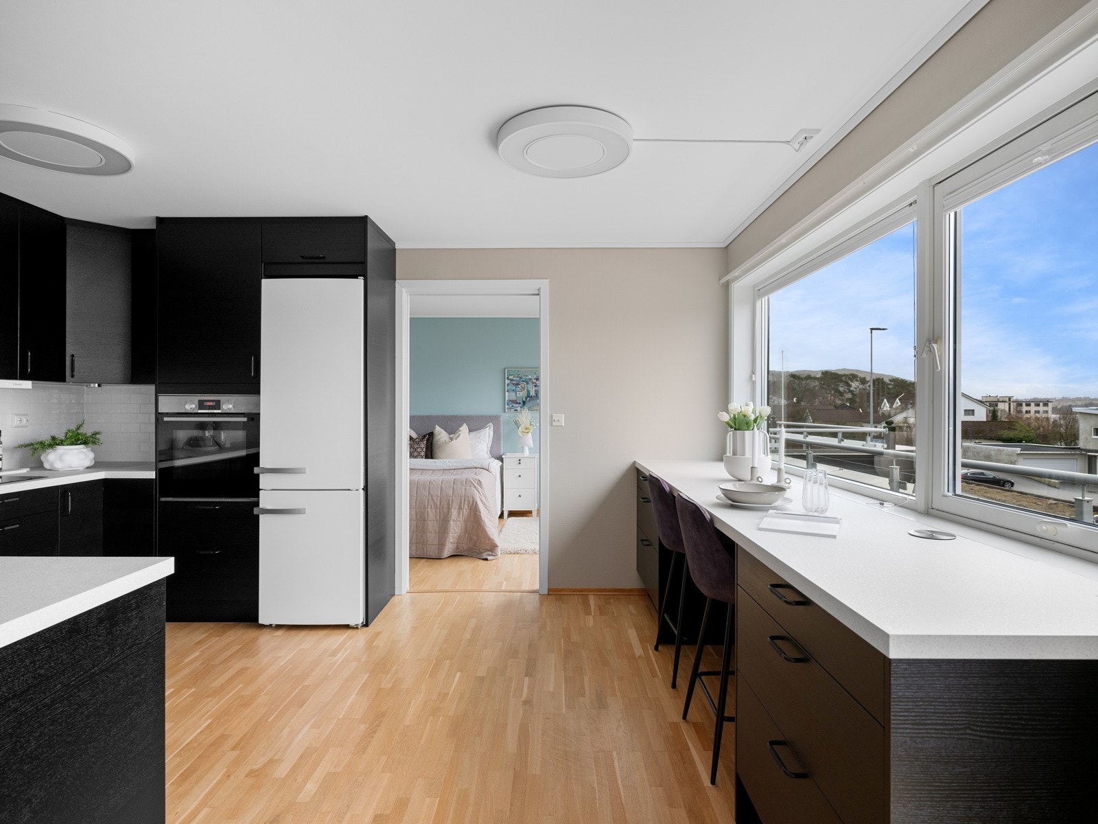 Kjøkkeninnredningen er fra 2022 og har et stilrent uttryk med sorte, slette fronter og hvit laminat benkeplate med underlimt oppvaskkum. Galleribilde